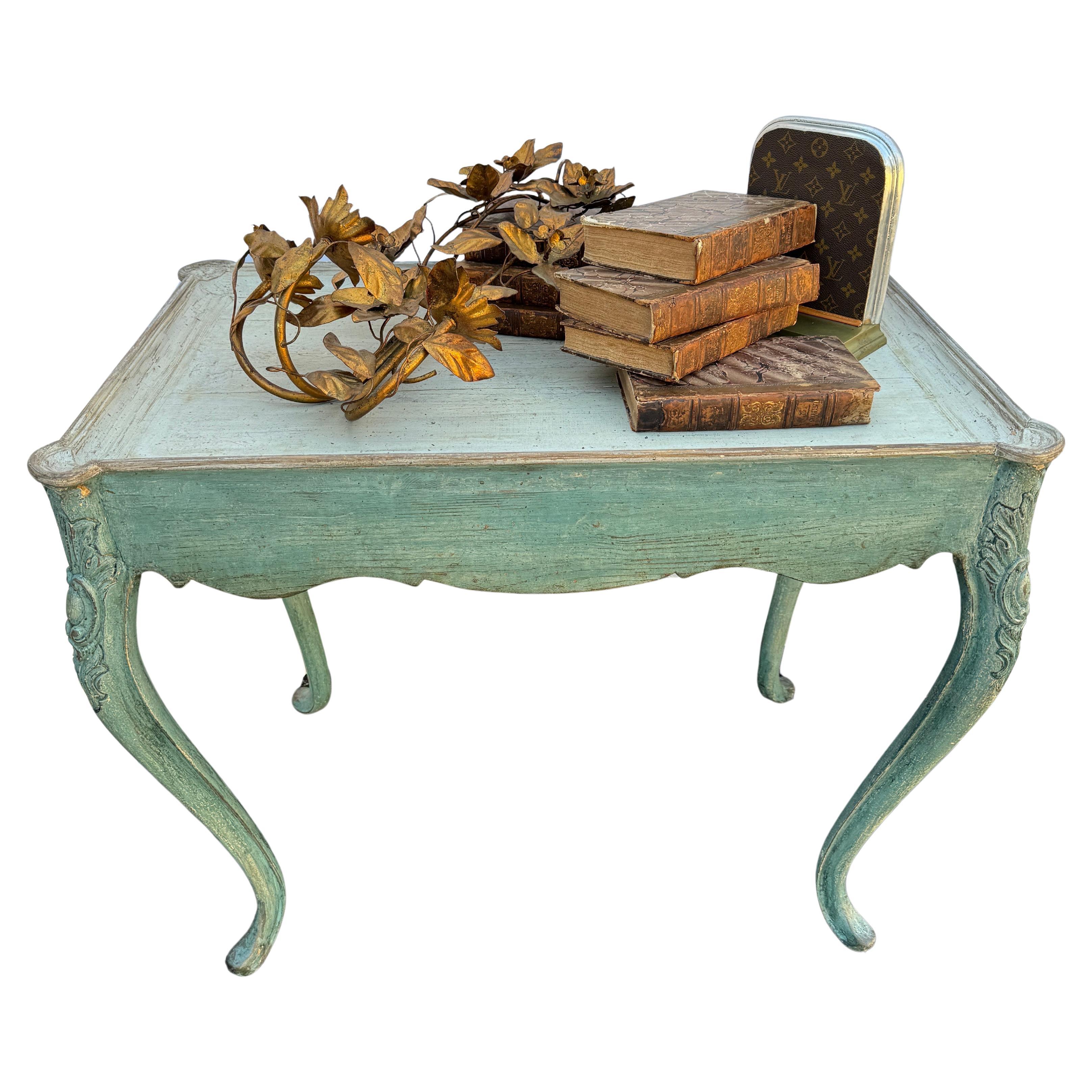 Hand painted and hand distressed wood side table with carved cabriole legs in a muted Scandinavian blue green color. The elegance and classic style of this piece with scalloped carved edges is equally at home in the country or traditional room and