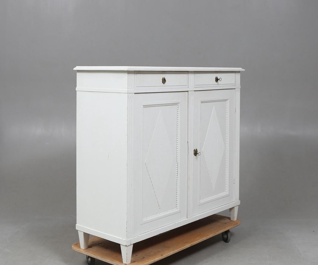 Circa 1870/1890 antique Swedish Gustavian White painted Sideboard Buffet commode in gustavian style with classic Gustavian diamond ribbing detail on the drawer fronts and leading edges. 

It has pyramid feet, ribbed top edge and  internal shelves