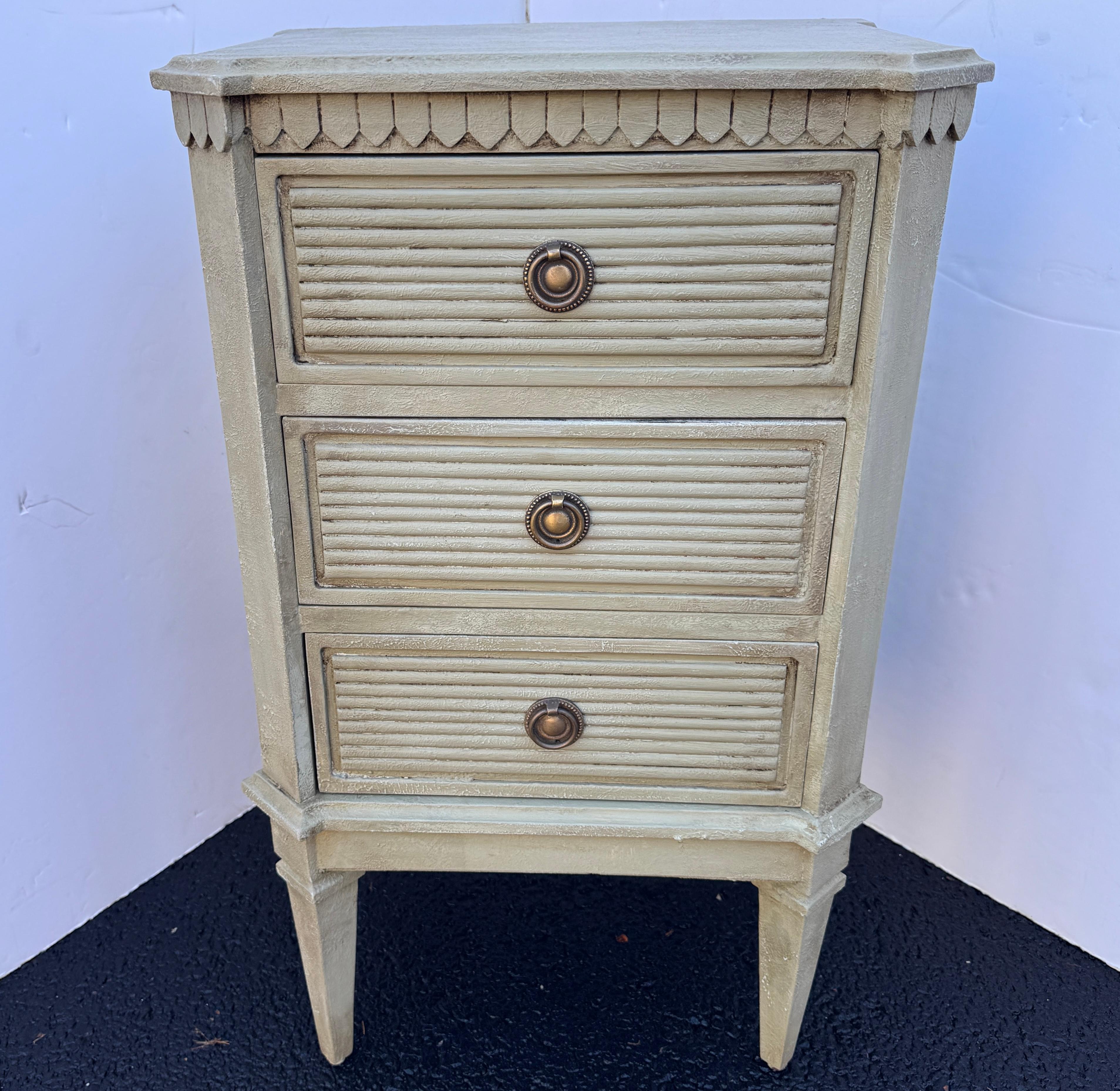 Hand painted, in a wonderful Scandinavian neutral green color, Gustavian style chest of drawers or nightstand. This piece has been constructed from solid wood with a hand-applied distressed finish with brass ring hardware. These classic Swedish