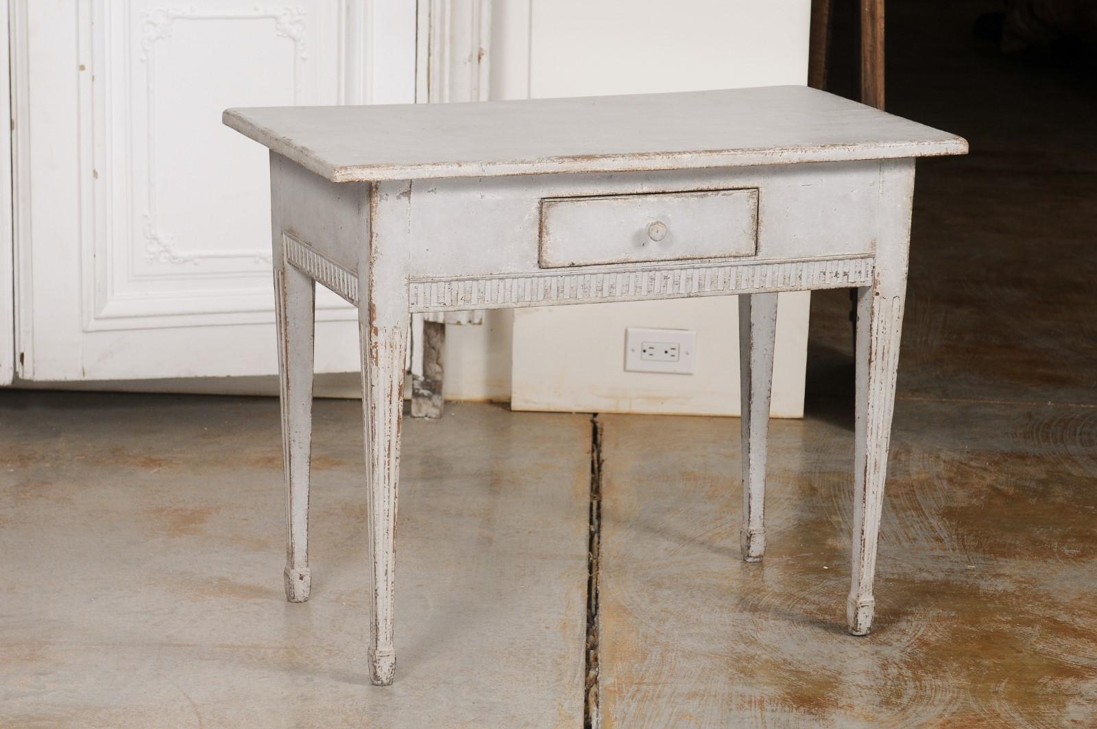 A Swedish Gustavian period freestanding painted console table from the late 18th century, with single drawer, fluted accents and tapered legs. Created in Sweden during the last decade of the 18th century, this painted table features a rectangular