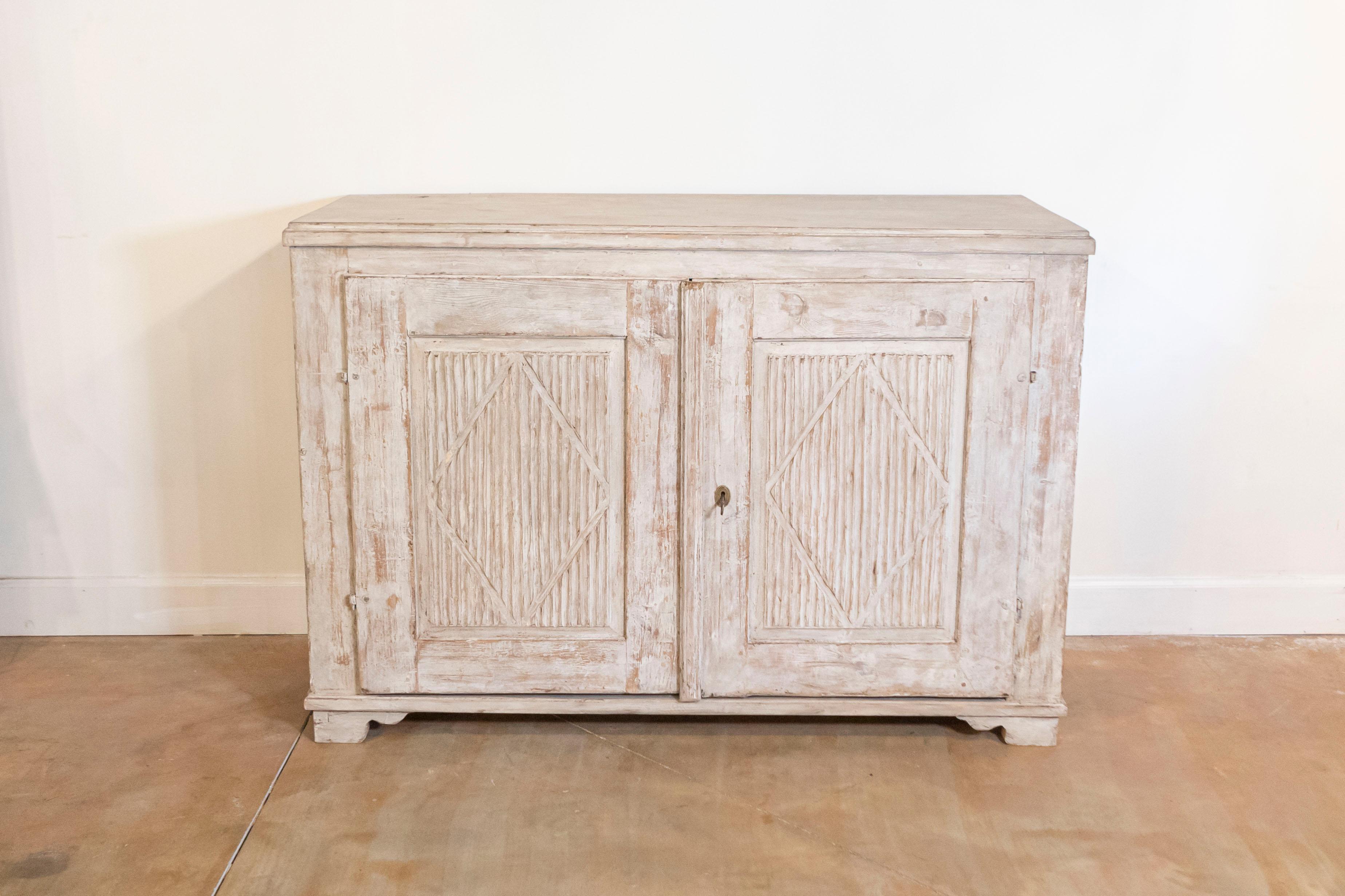 Aparador sueco de madera pintada de principios del siglo XIX, de la época Gustaviana, con puertas reed, motivos romboidales y pies de ménsula conopiales tallados. Creado en Suecia durante el primer cuarto del siglo XIX, este aparador gustaviano