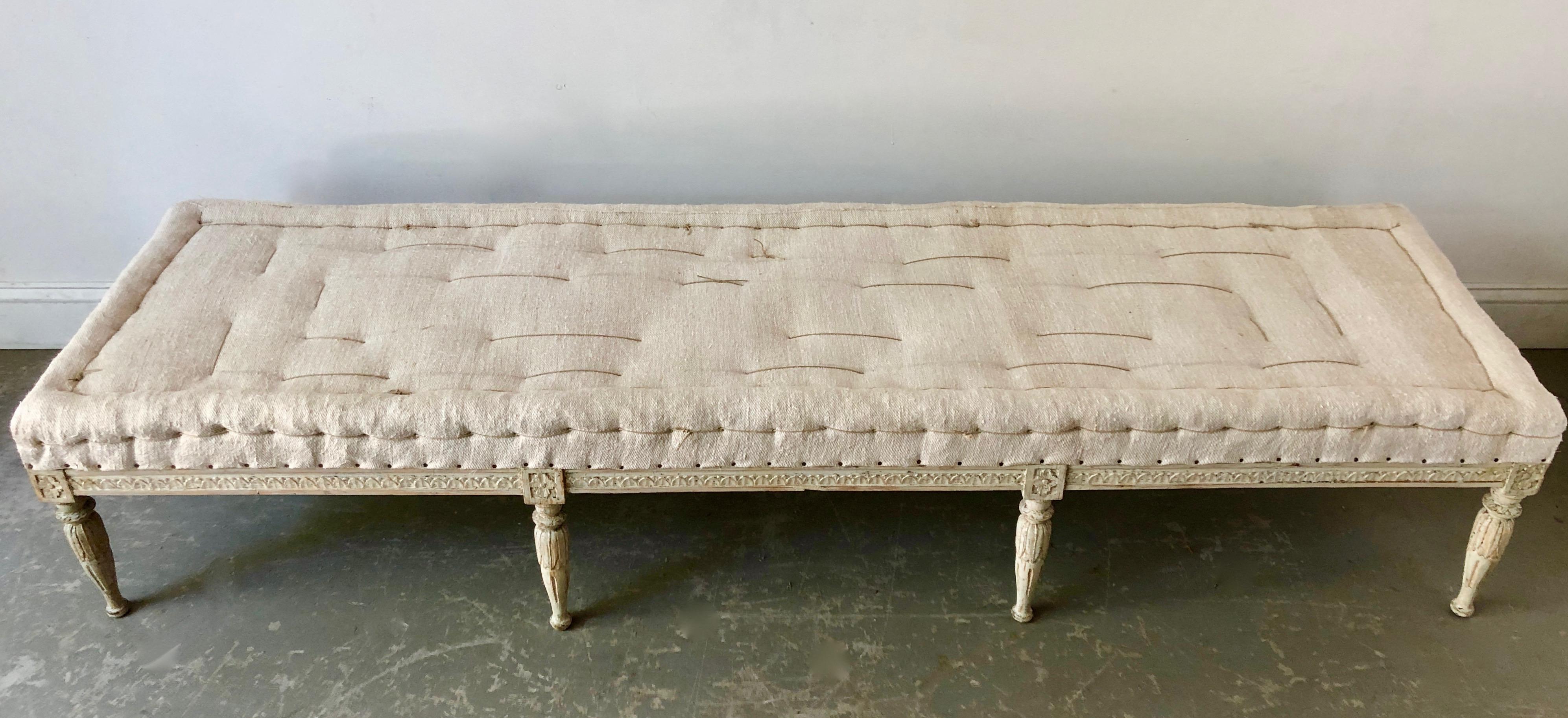 Very rare. Swedish Gustavian period bench, circa 1810, finished on all four sides with Guilloché carvings on carved round fluted legs. Scraped to original cream /white finish and upholstered in traditional way in antique handstitched linen. Timeless