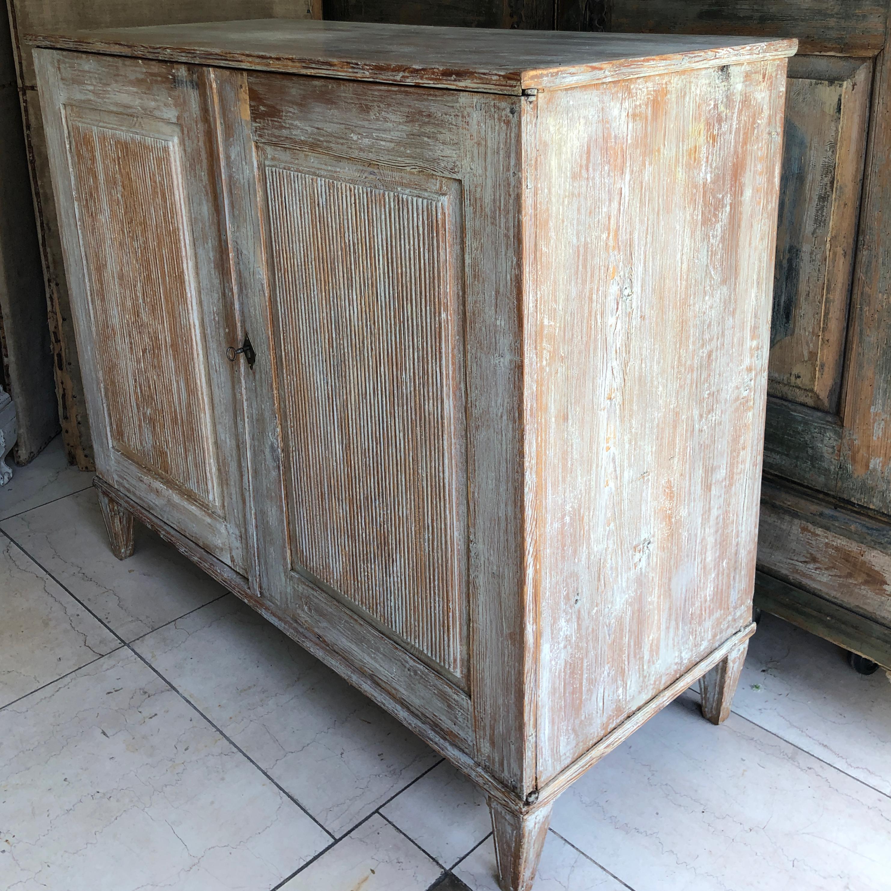 An elegant, very large Gustavian period sideboard with beautifully carved reeded and panelled door fronts on fluted tapered feet. Later paint scraped off to its most original finish.
Uppsala, Sweden, circa 1800-1810.