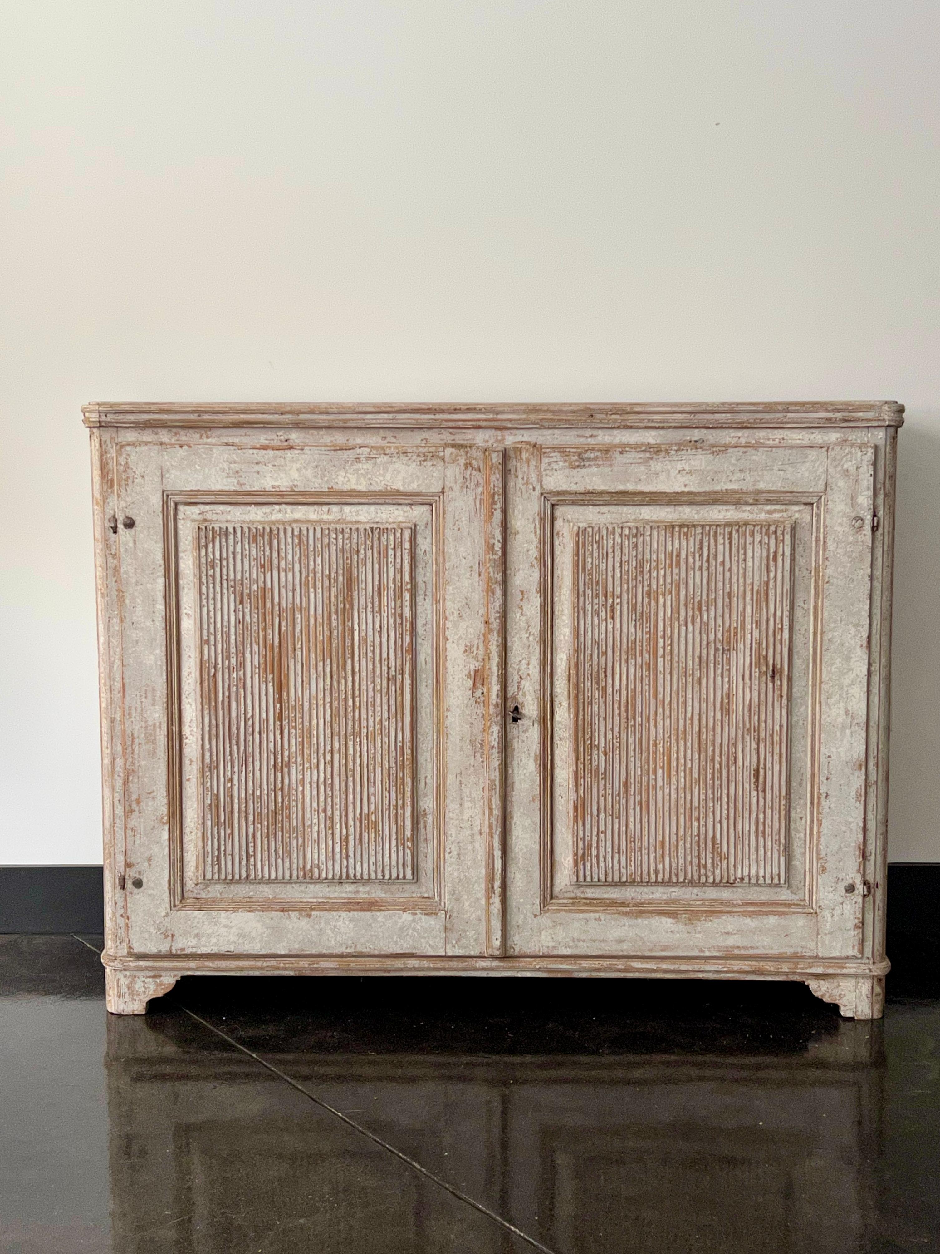 An classic, very large Gustavian period sideboard with beautifully carved reeded and panelled door fronts on shaped block feet. Later paint scraped off to its most original finish.
Uppsala, Sweden, circa 1800.