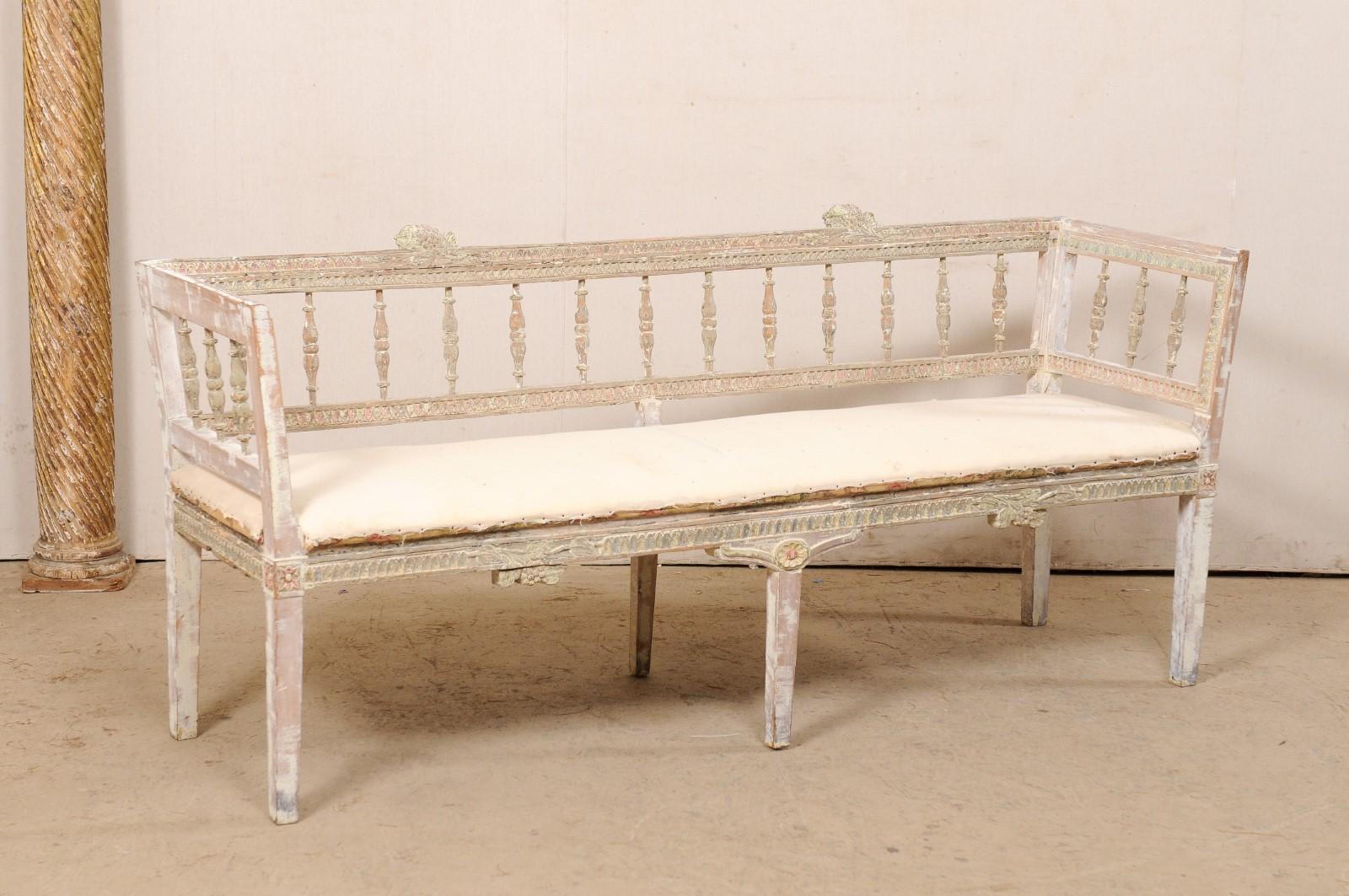 A Swedish Lindome carved-wood sofa bench from the early 19th century. This period Gustavian bench comes from the Lindome region of Sweden; a region known for master craftsman in wood working. Nicely carved spindle back splats are set within a