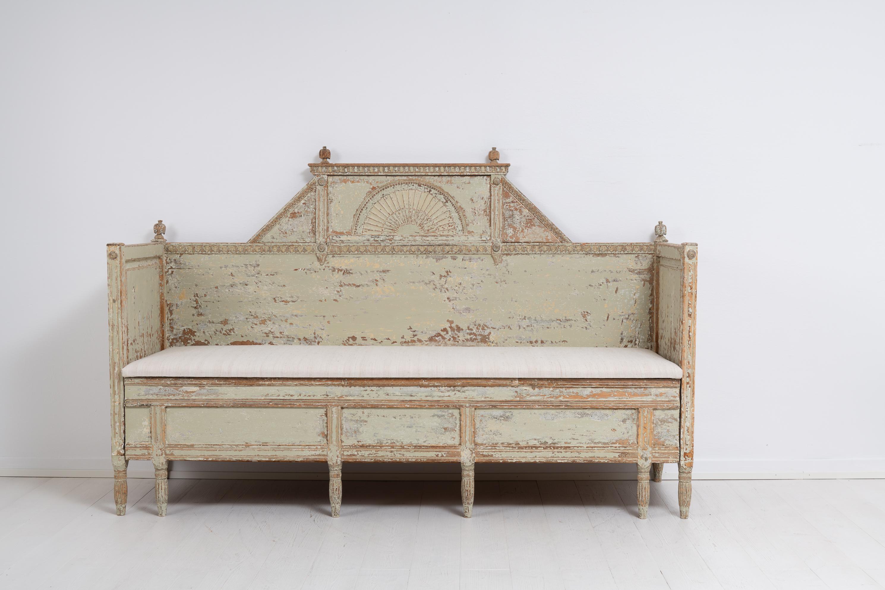 Gustavian sofa from Northern Sweden and a classic example of antique Swedish country house furnitures. The sofa is pine and dry scraped to the original first layer of paint. The hand-made decor on both the front, backrest and armrests is very
