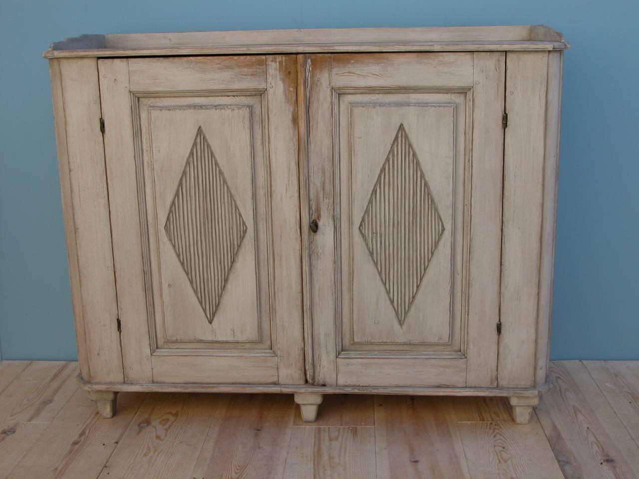 Swedish Gustavian sideboard, circa 1795, Origin: Sweden, two doors, each with hand-carved with a diamond motif, shelved interior.

The charming, imperfect hand-carved diamond designs on each door reveal the 18th century cabinetmakers hand at work. 