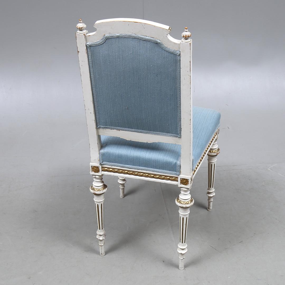 Dieser original schwedische Gustavianische Stuhl aus den frühen 1900er Jahren in wahrscheinlicher Originalfarbe hat stark geschnitzte Details am Rahmen, den Armlehnen und den Beinen, ungewöhnliche zart geriffelte Füße und eine breite