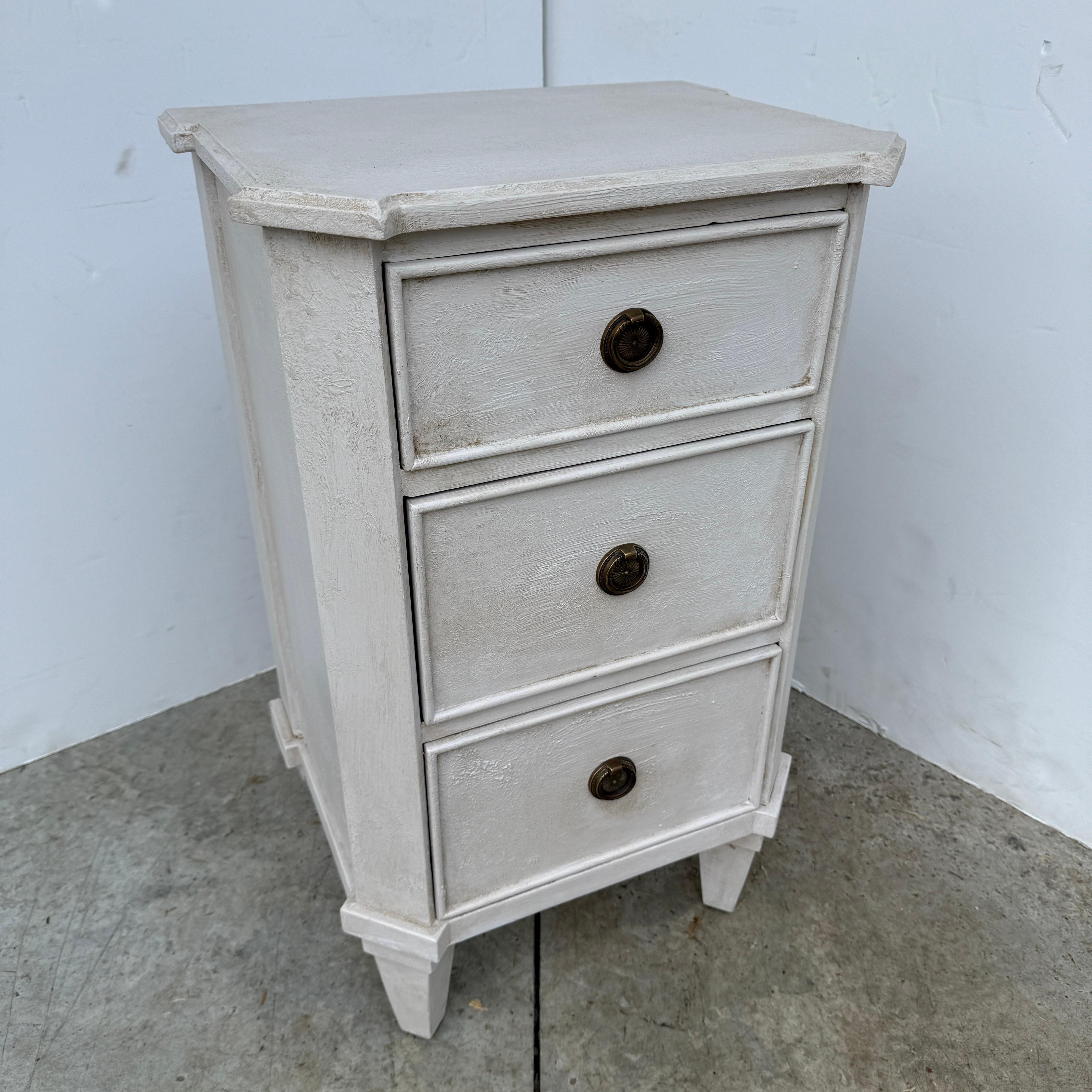 Commode ou table de nuit de style gustavien, peinte à la main, dans une magnifique couleur scandinave neutre gris crème. Cette pièce a été construite en bois massif avec une finition vieillie appliquée à la main et des anneaux en laiton. Ces