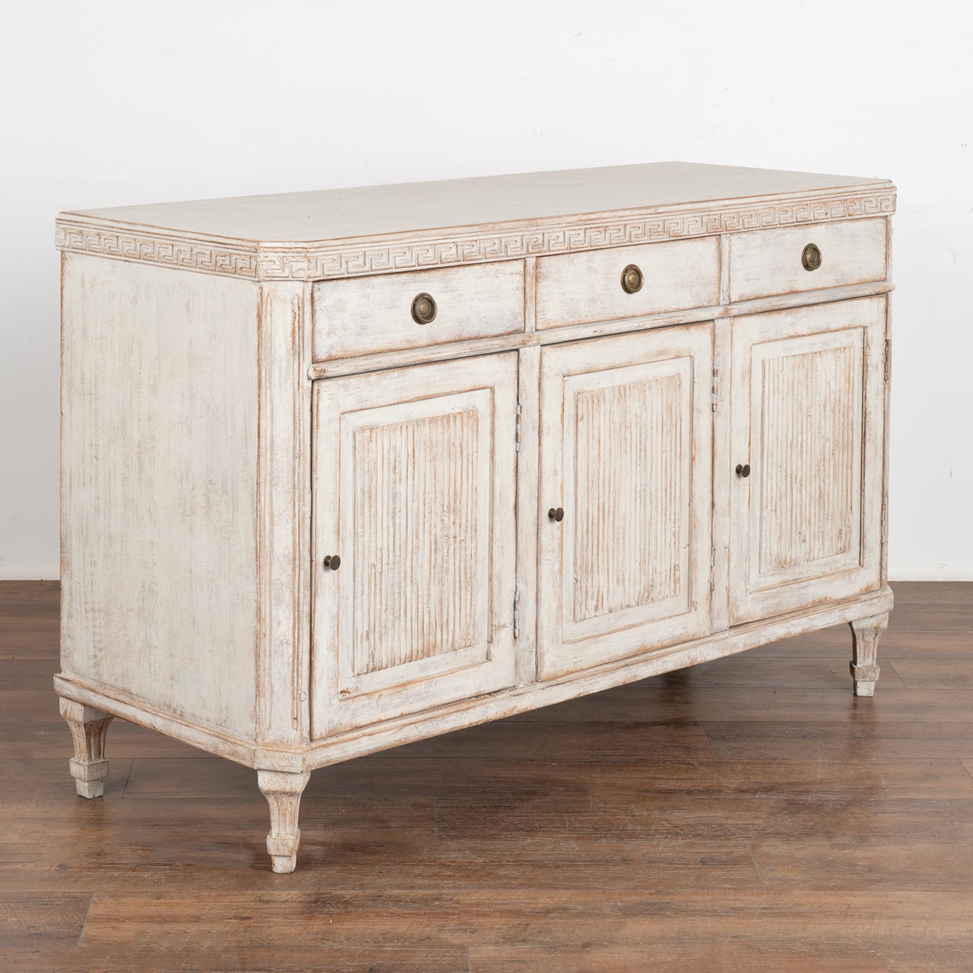 Gustavian white painted pine sideboard or console with one interior shelf (see photos to understand cut-out shape of shelf).
Traditional fluted panel doors, Greek key or 