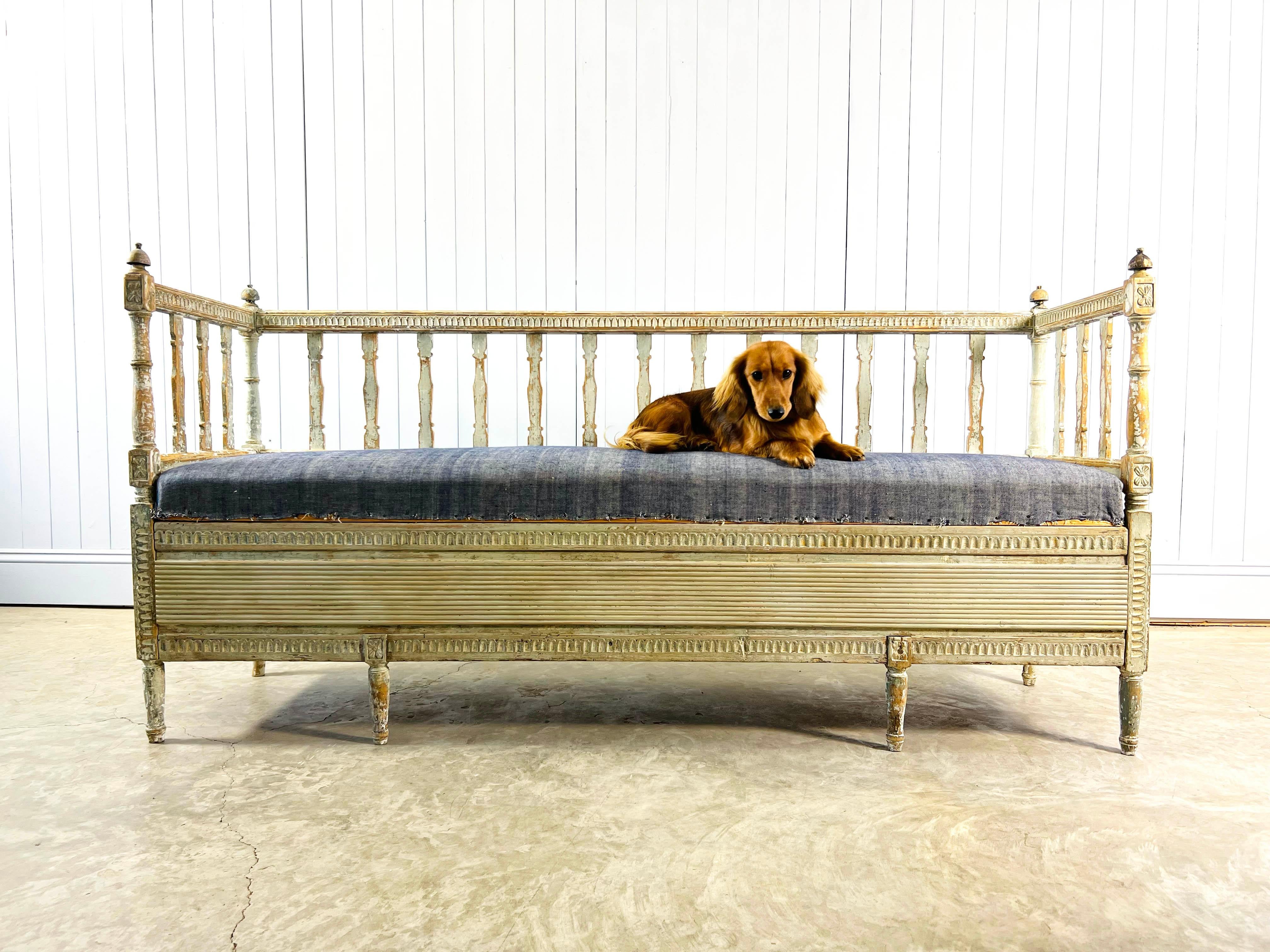 We love these stunning 19th century Gustavian Swedish benches. This beautifully carved bench with storage has fantastic details. An absolute multi functional Swedish daybed. The paint has been dry scraped back to reveal some of the older colours