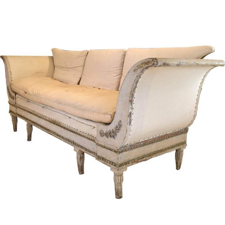 Sweeping graceful sides are accented with flower and leaf garland. Egg & dart carving decorates the three sides of the base of the sofa. Upholstered in European burlap.