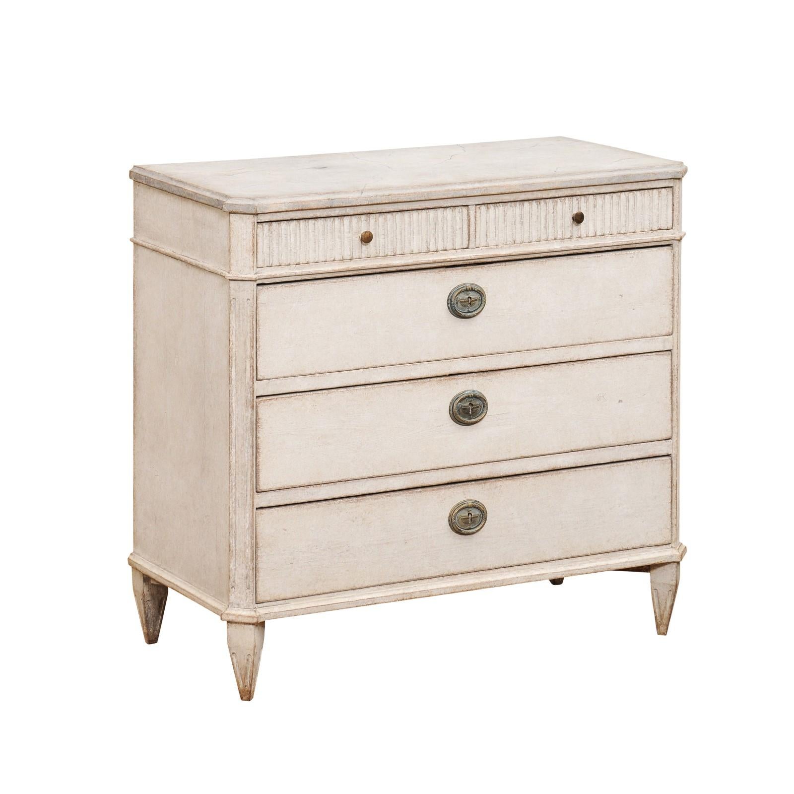 A Swedish Gustavian style painted chest circa 1860 with five drawers, discreetly marbleized top, carved fluted accents, tapered feet and fluted side posts. Experience the quiet elegance of Scandinavian design with this Swedish Gustavian style