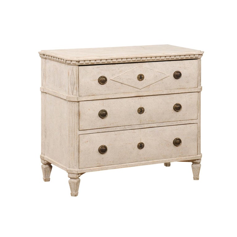 A Swedish Gustavian style painted wood chest of drawers from the late 19th century, with marbleized top, dentil molding, diamond motifs and fluted accents. Created in Sweden during the last quarter of the 19th century, this painted chest features a