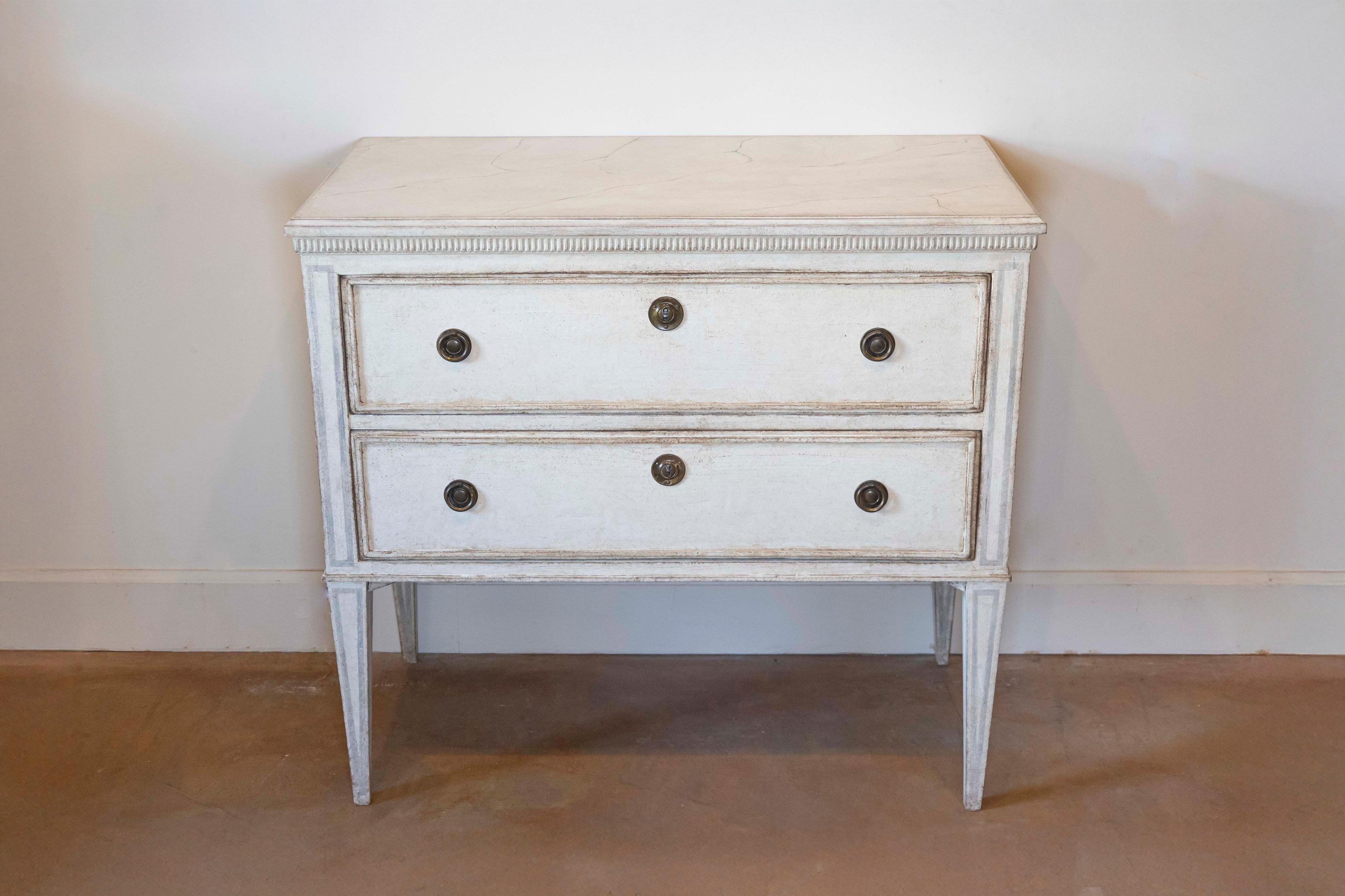 Cassettone svedese dipinto in stile gustaviano del 1890 circa con due cassetti, modanature scanalate intagliate, contorni dipinti in grigio chiaro e gambe affusolate. Abbraccia il fascino intramontabile del design nordico con questa cassapanca