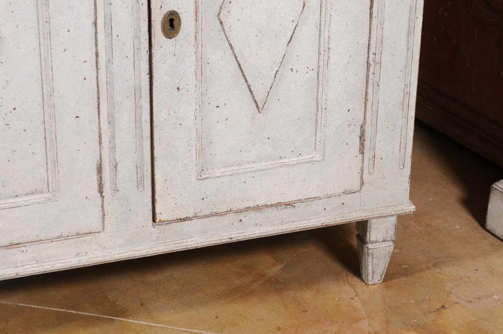 A Swedish Gustavian style painted wood sideboard from the late 19th century, with three doors and diamond motifs. Created in Sweden during the last decade of the 19th century, this painted sideboard features a rectangular top sitting above three