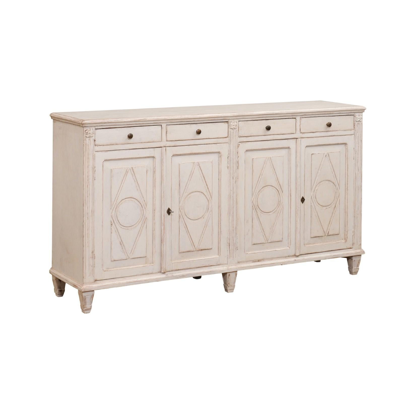 Swedish 19th century Gustavian Style painted enfilade with four drawers over two pairs of double doors. Immerse in the tranquil simplicity of Scandinavian design with this exquisite 19th century Swedish Gustavian Style painted enfilade. Reflecting