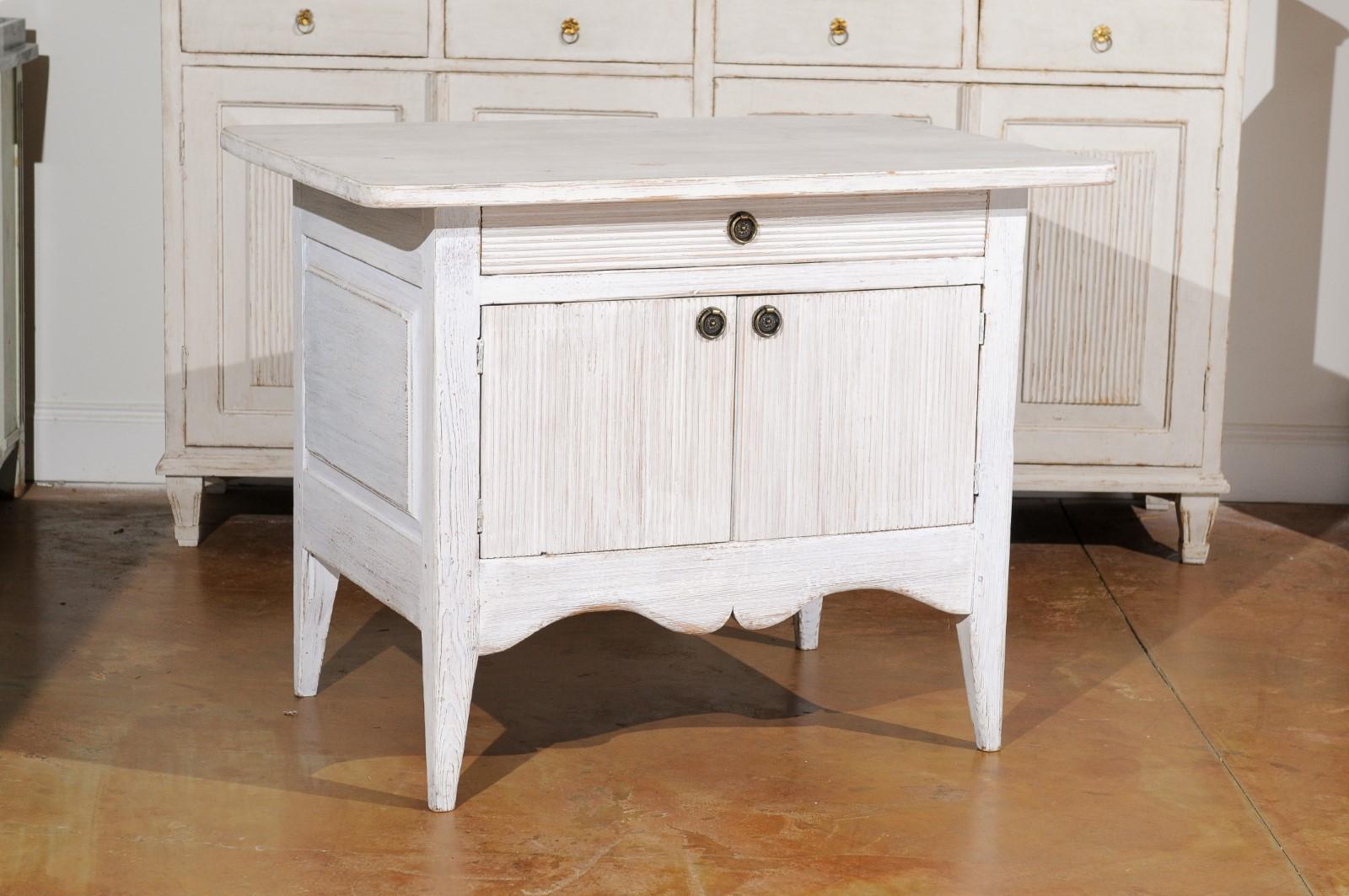 A Swedish Gustavian style painted sideboard from the 19th century, with reeded motifs, single drawer over double doors. Created in Sweden during the 19th century, this painted sideboard features a rectangular top with rounded corners, overhanging a