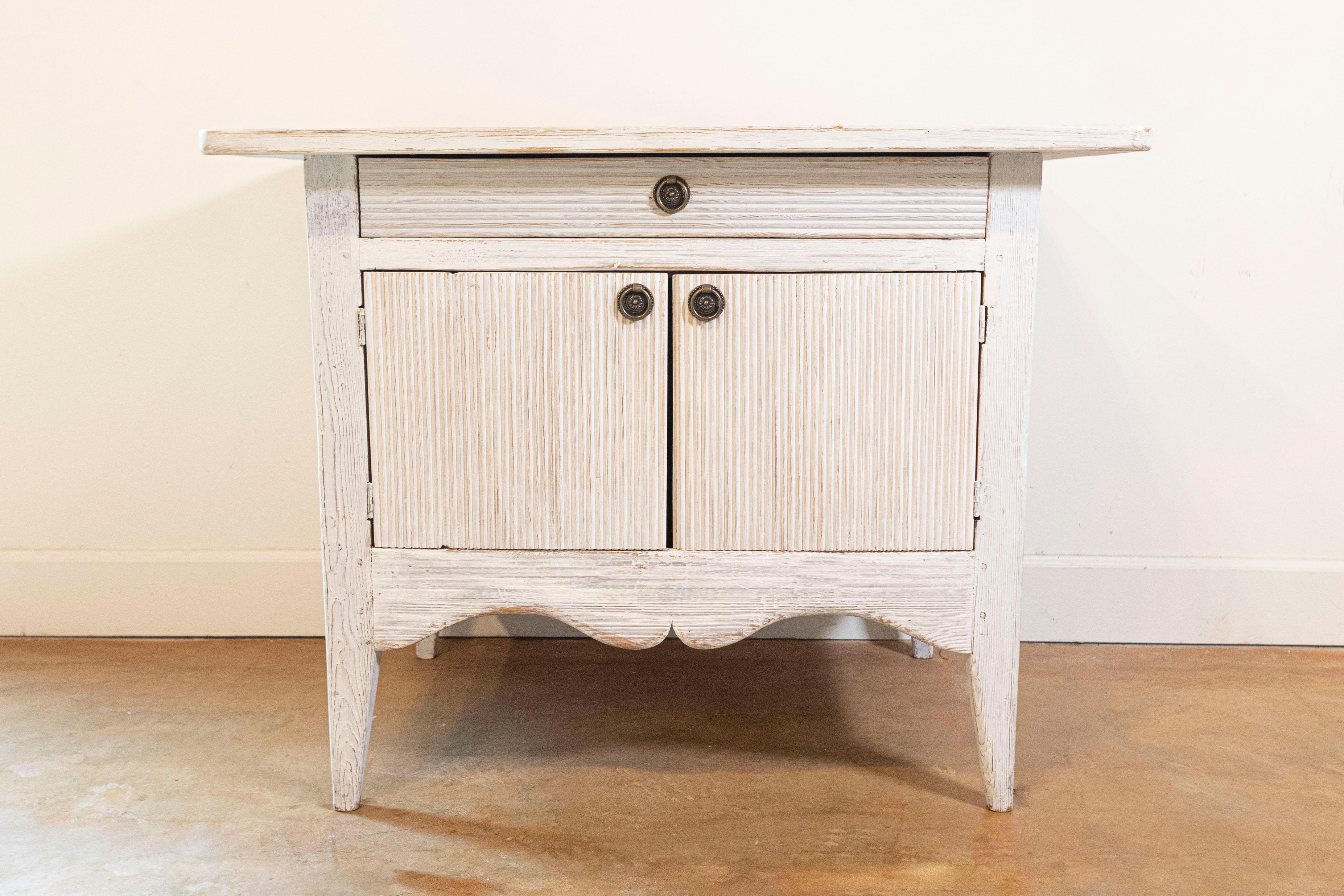 Buffet suédois peint de style gustavien du XIXe siècle, avec des motifs cannelés, un seul tiroir sur deux portes. Créé en Suède au cours du XIXe siècle, ce buffet peint présente un plateau rectangulaire aux angles arrondis, surplombant un tiroir