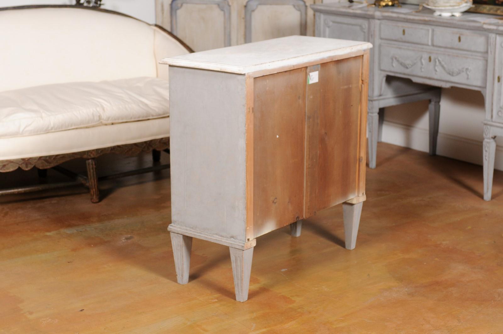 A Swedish Gustavian style painted wood sideboard from the 19th century, with reeded and fluted motifs. Created in Sweden during the 19th century, this Gustavian style sideboard features a rectangular top with beveled edges, sitting above a single