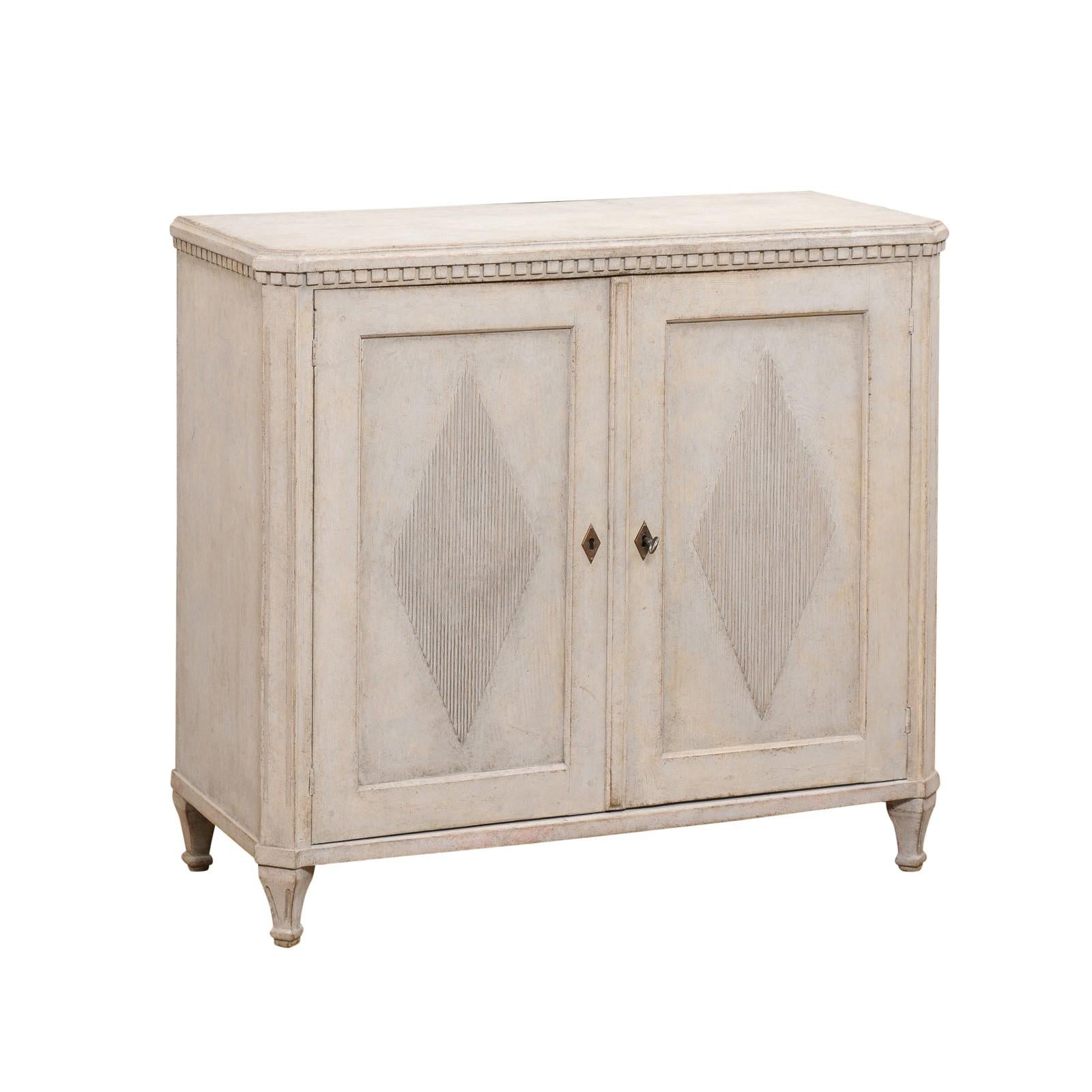 A Swedish Gustavian Style painted wood sideboard from the 19th century, with dentil molding, reeded diamond motifs and tapered feet. Created in Sweden during the 19th century, this sideboard showcases the stylistic characteristics of the Gustavian