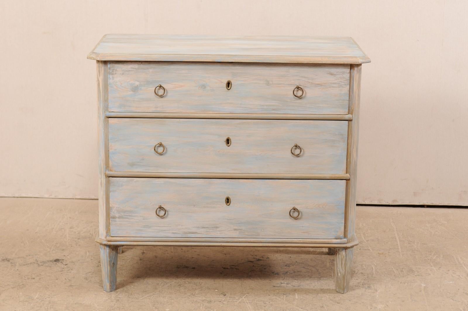A Swedish painted wood three drawer chest from the mid-19th century. This antique chest from Sweden has been designed in typical Gustavian style, featuring a simple, clean design with slanted side posts and feet, and each top forward corner