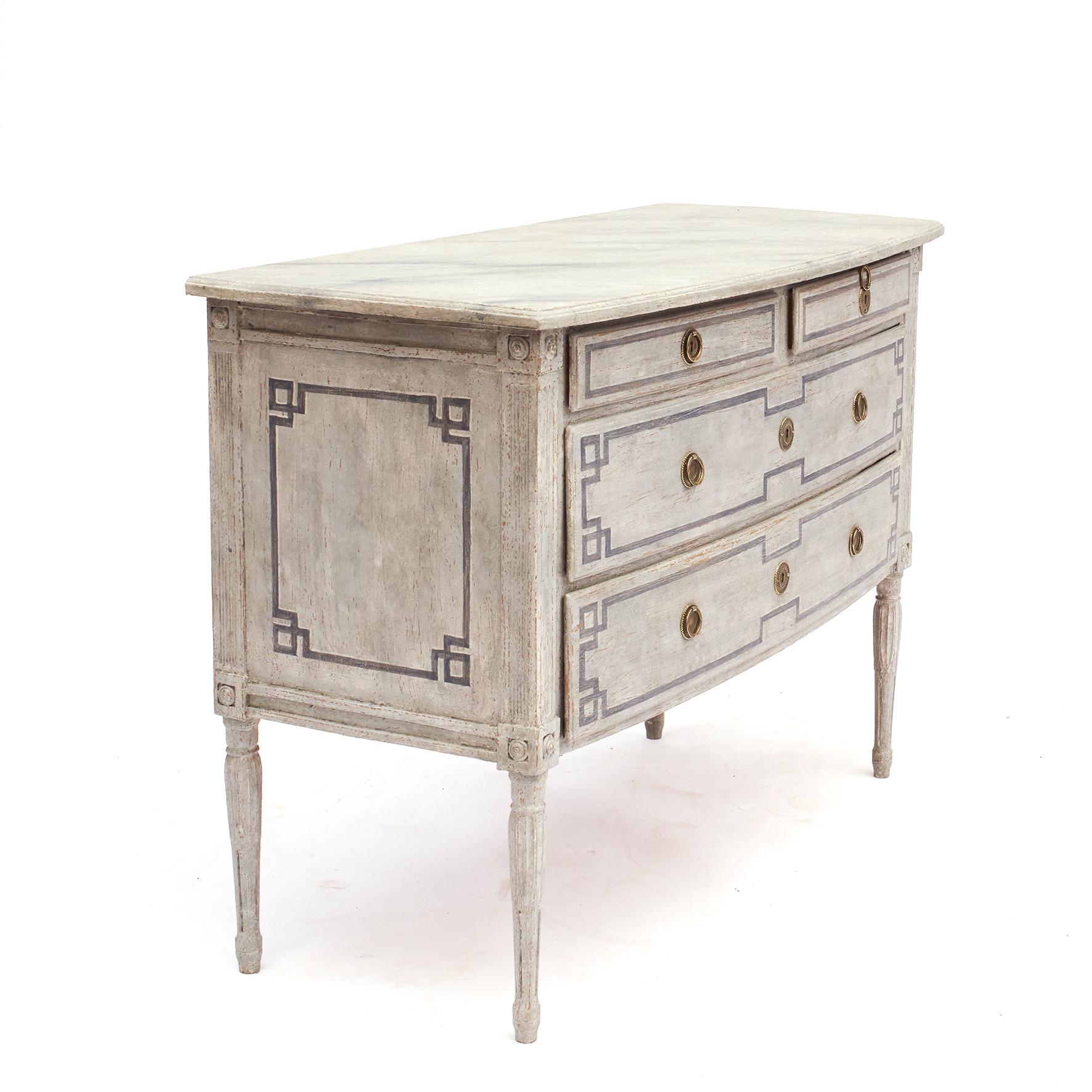 Swedish Gustavian style chest of drawers painted in blue shades.
Features a rectangular blue-grey marbleized wooden top above a curved front. Four drawer flanked with side posts showcasing fluted motifs, resting on four turned fluted legs.
A