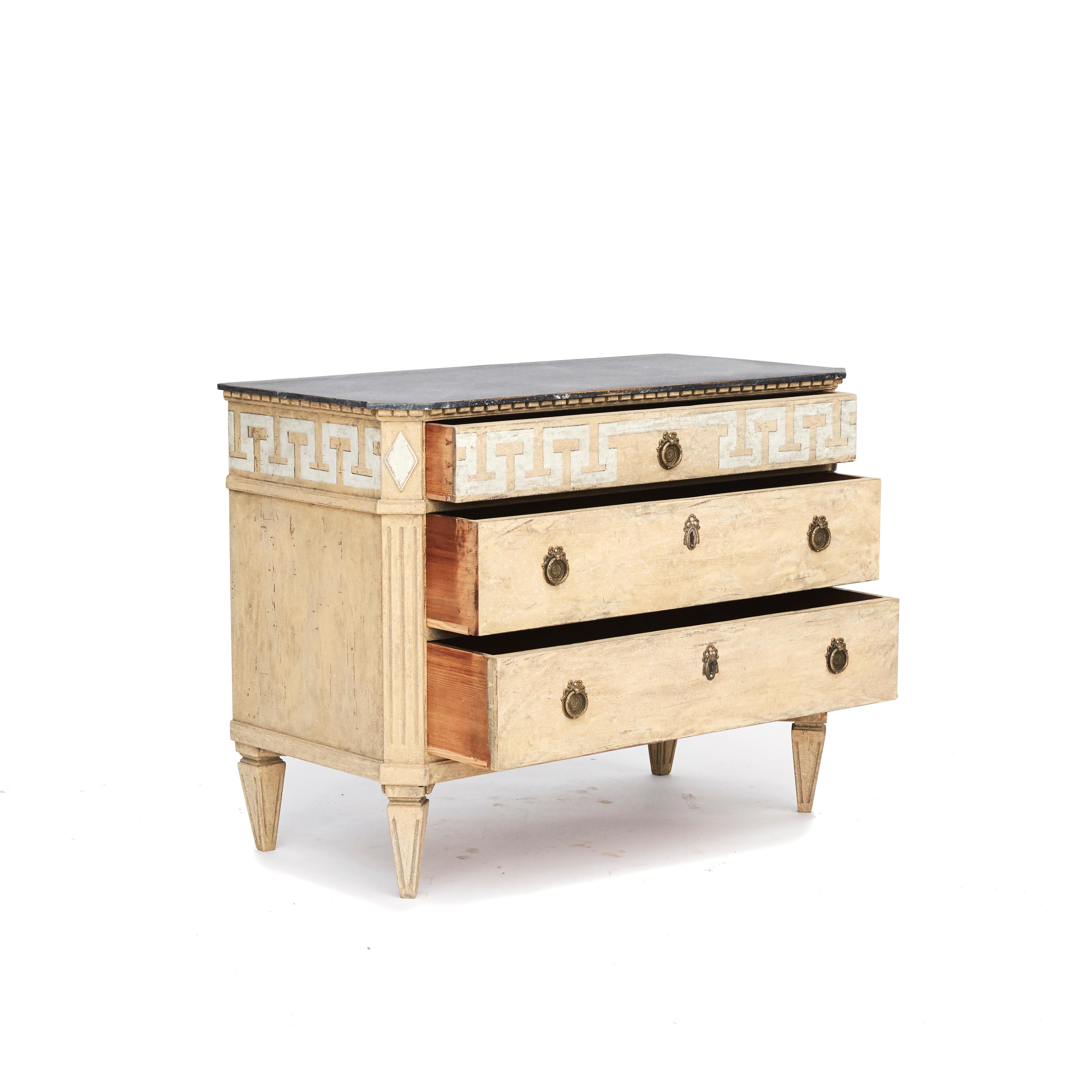 Decorative Swedish Gustavian Style chest of drawers painted in dusty antique yellow, typical of the Scandinavian taste for light palettes.
Wooden blue-gray faux marbled tabletop and dentil moldings.
Three drawer, upper drawer decorated with white