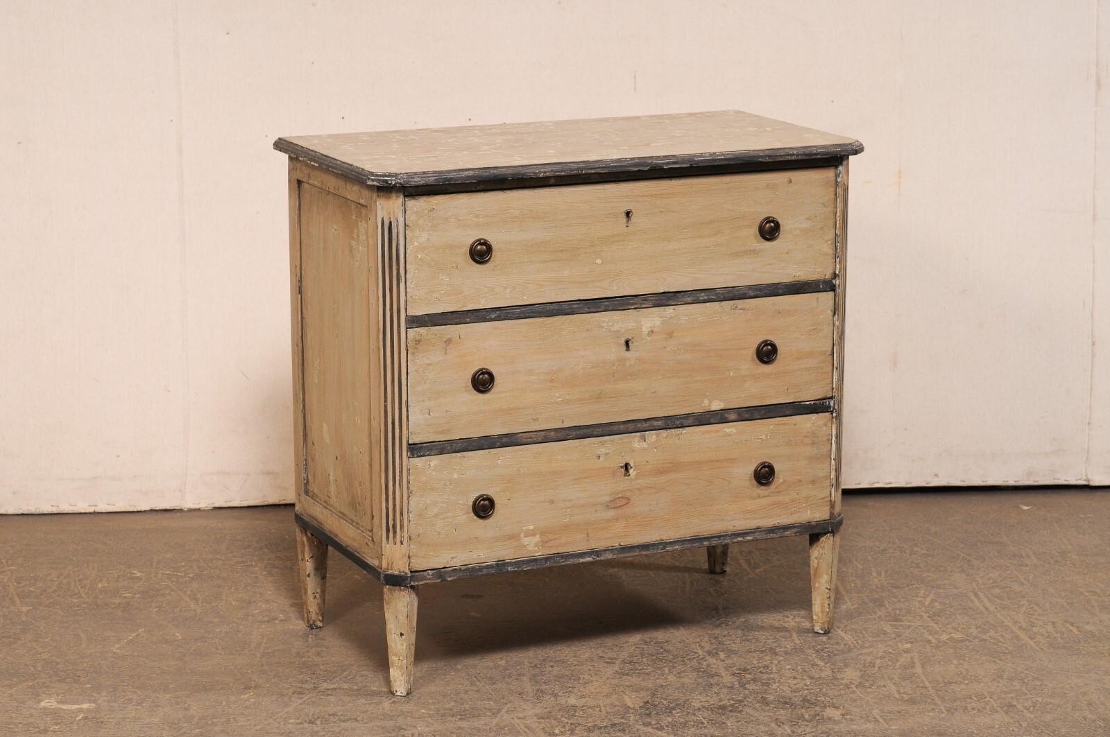 A Swedish Gustavian style chest of drawers from the early 20th century. This antique chest from Sweden, designed in typical Gustavian style, features a simple, clean design with canted front side posts adorned with fluted carving. The top is
