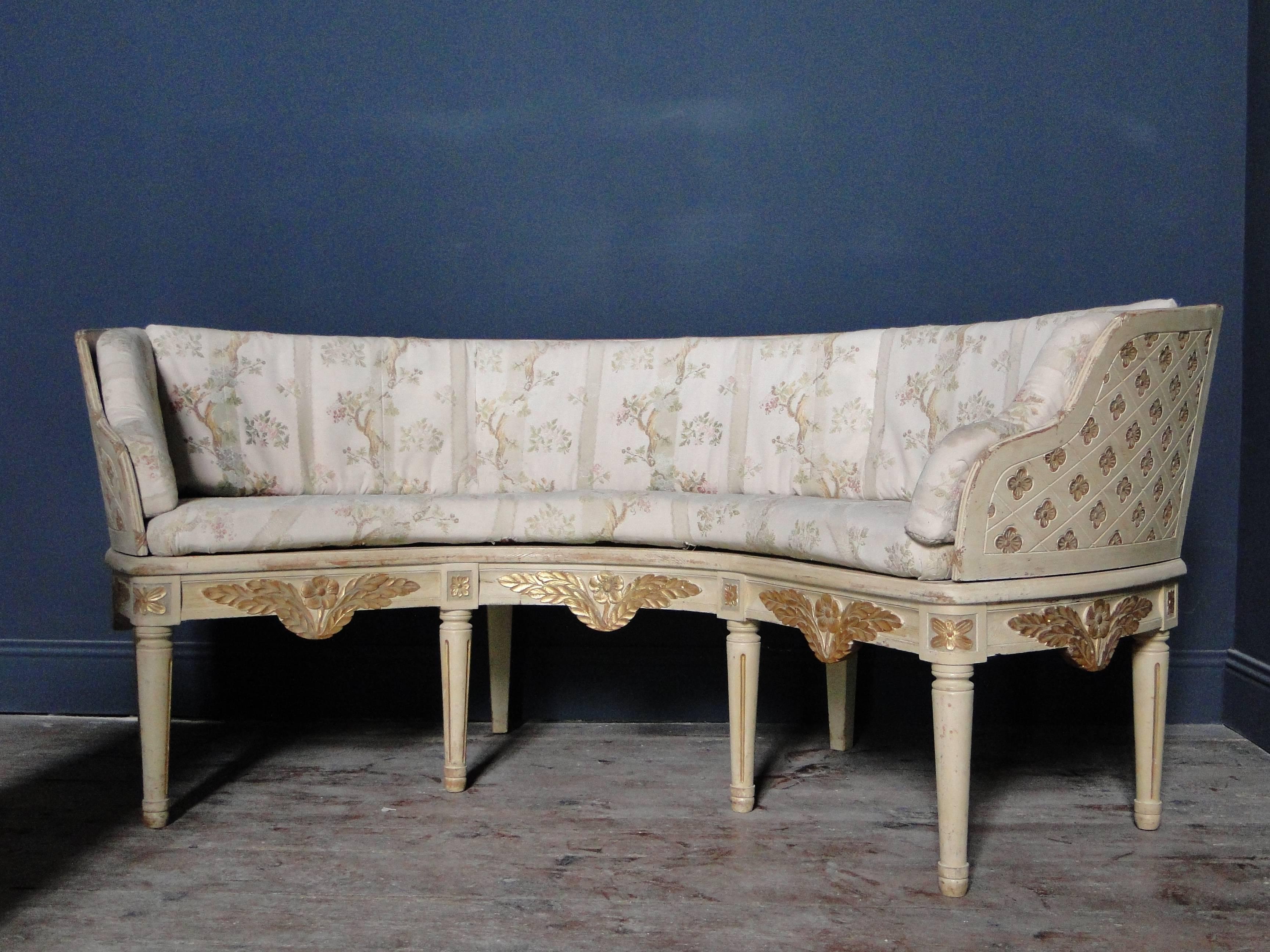 Swedish sofa, curved formed, painted wood, partly gilded. Measures 192 cm long and 60 cm deep. Seat height 49cm. The wooden back part is removable .Faded fabric cushions which are original. Origin Fållans Gård, Trångsund, Sweden.