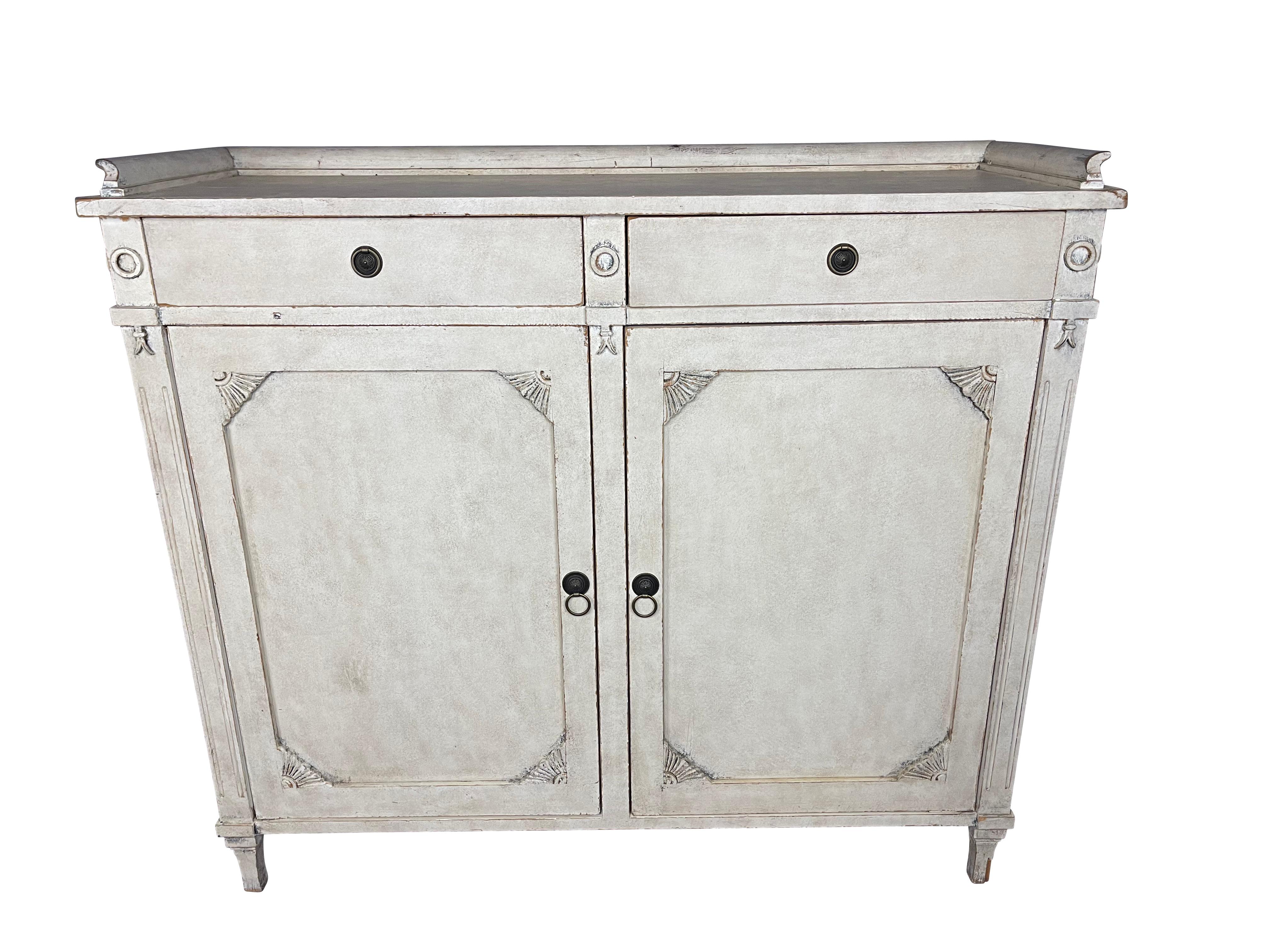 Gustavian-style buffet cupboard with original paint, 19th century, Sweden, circa 1840. Beige Lime Washed Cabinet, 3/4 gallery top above two frieze drawers over two paneled doors which open to reveal an interior shelf.
Sublime 19th century Swedish