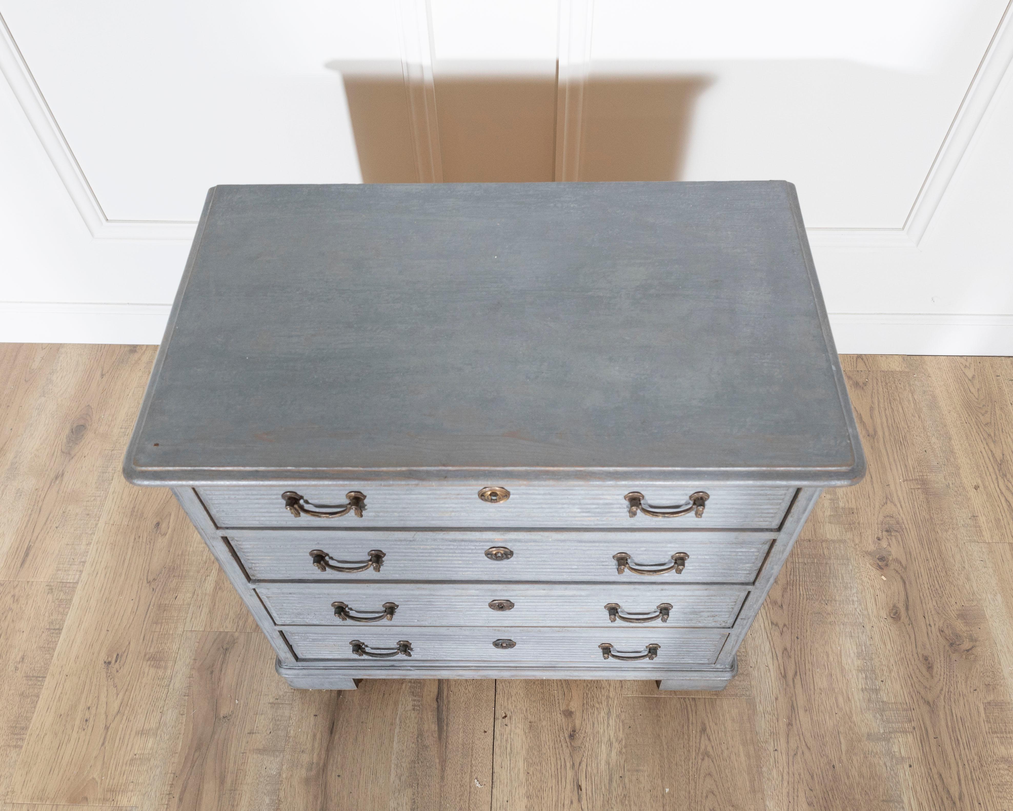 A charming small chest of drawers in the Gustavian style, crafted in Sweden circa 1960. Painted in a soft gray tone, the piece reflects the clean lines and refined elegance associated with Gustavian design. The façade features delicate horizontal