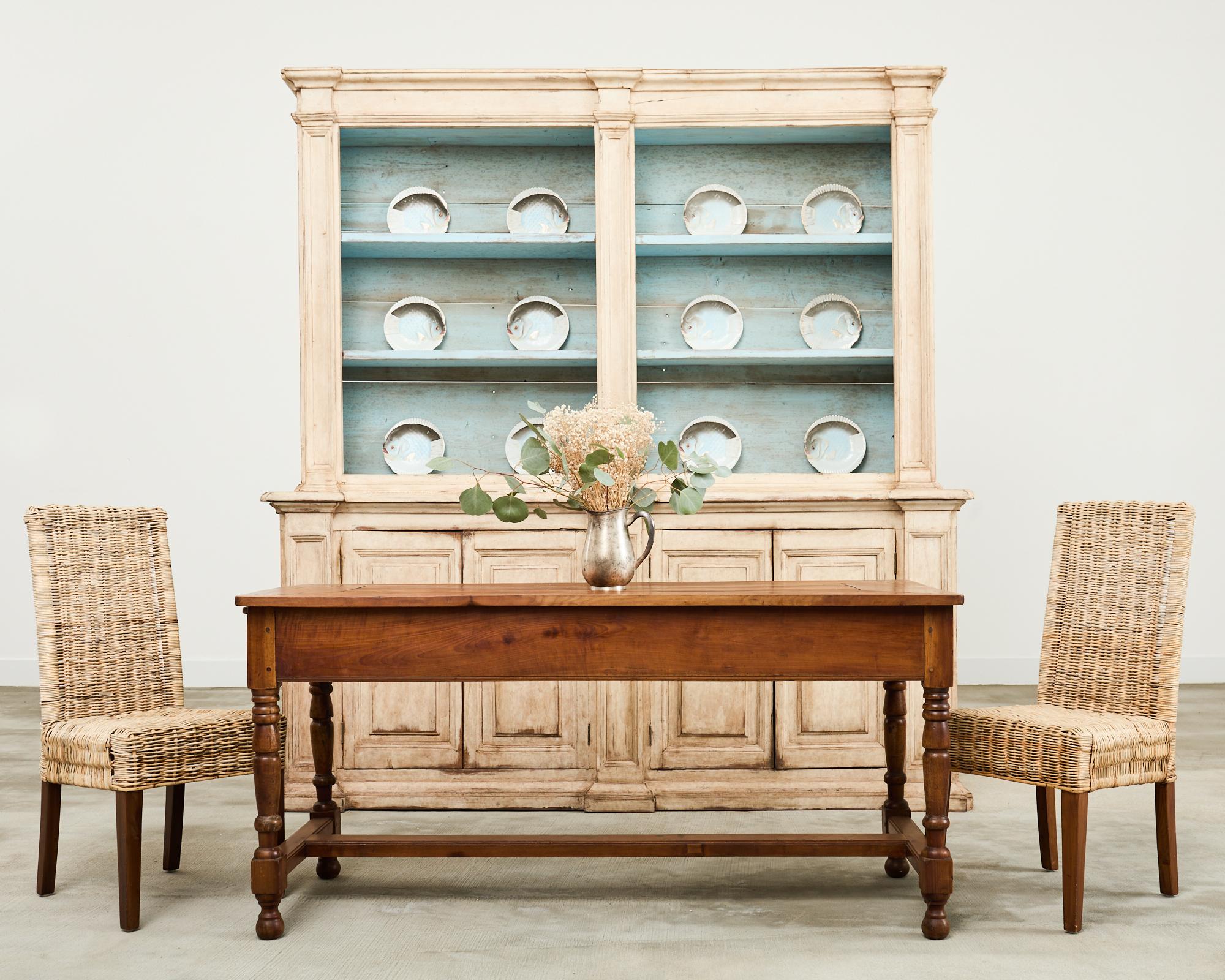 Gorgeous large two-part bookcase cabinet featuring a weathered painted finish in the Swedish Gustavian taste. Crafted from pine in Italy with paneled sides and doors. The top piece has a three-shelf interior finished in a robin's egg light blue