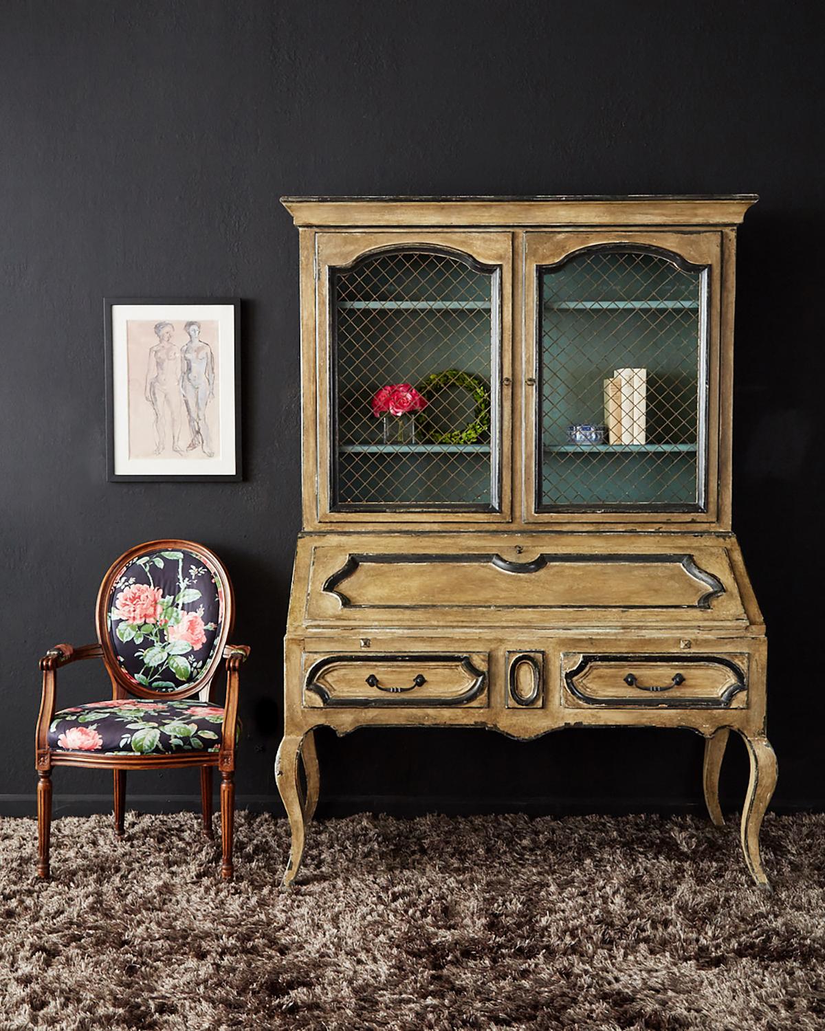 Remarkable two-part secretaire bookcase featuring a slant drop front desk. Made in the Swedish Gustavian taste with a gorgeous painted lacquer finish having a distressed patina. The bookcase has three shelves behind wire grilled doors. The case is