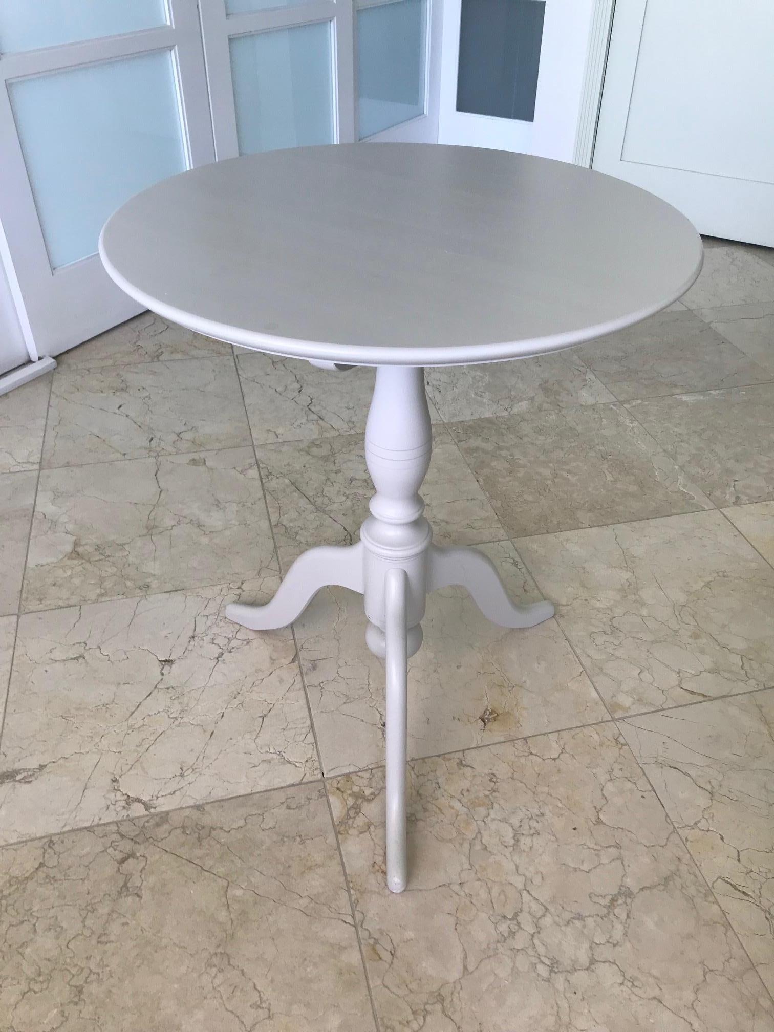 Based on Classic 19th century antique guéridon tables from Sweden featuring a round shaped tilt-top. This Gustavian style side table is hand painted in Classic gray / taupe finish. Elegant tilt-top over a turned wood pedestal base with hand carved