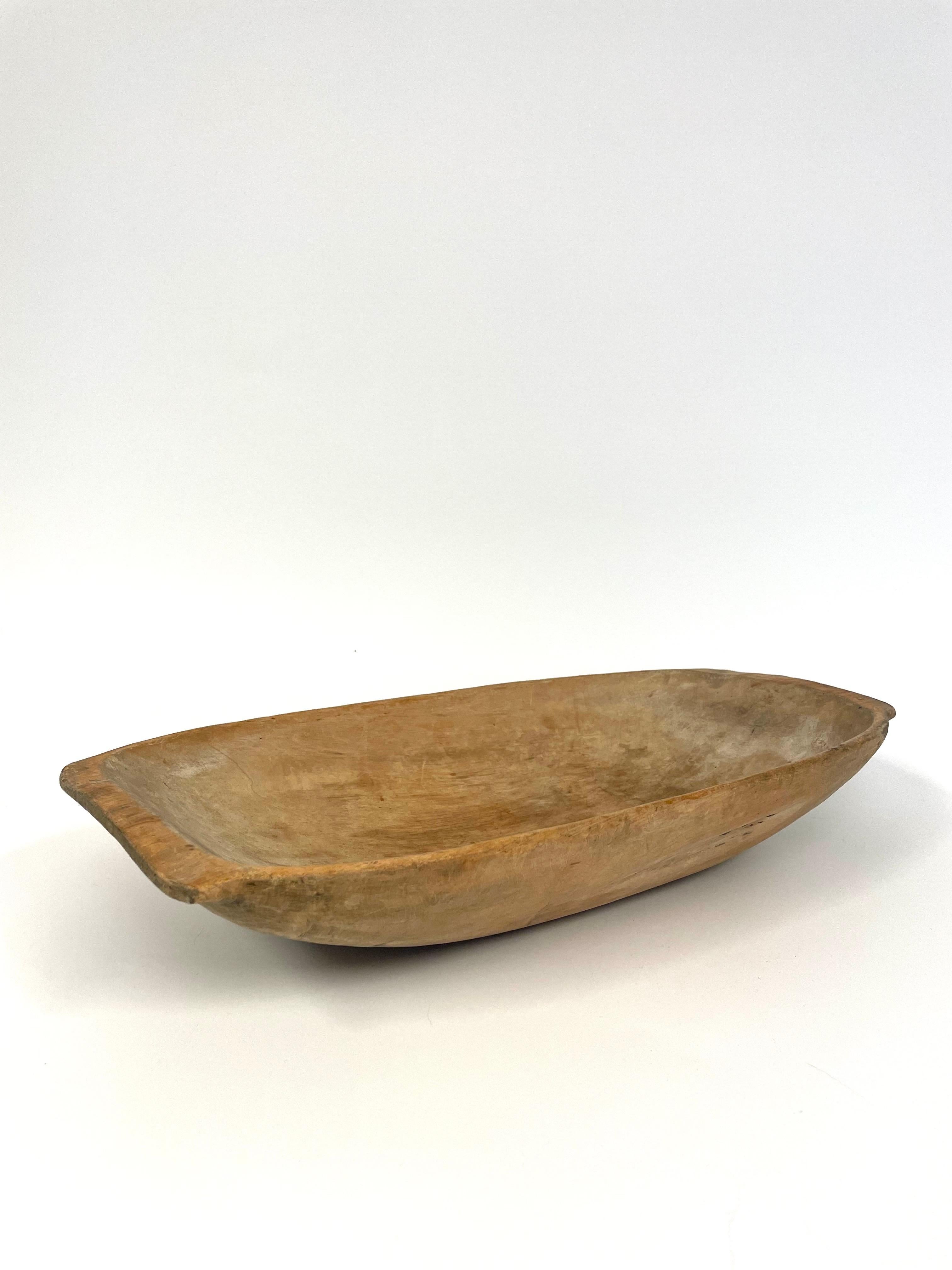 This is a very beautiful Swedish hand-carved 19th century wooden baking trough in Wabi Sabi style. 
It comes made in pine with lovely patina reflecting its age.

On both sides there are handles. To carry, of course, but above all to get a good grip