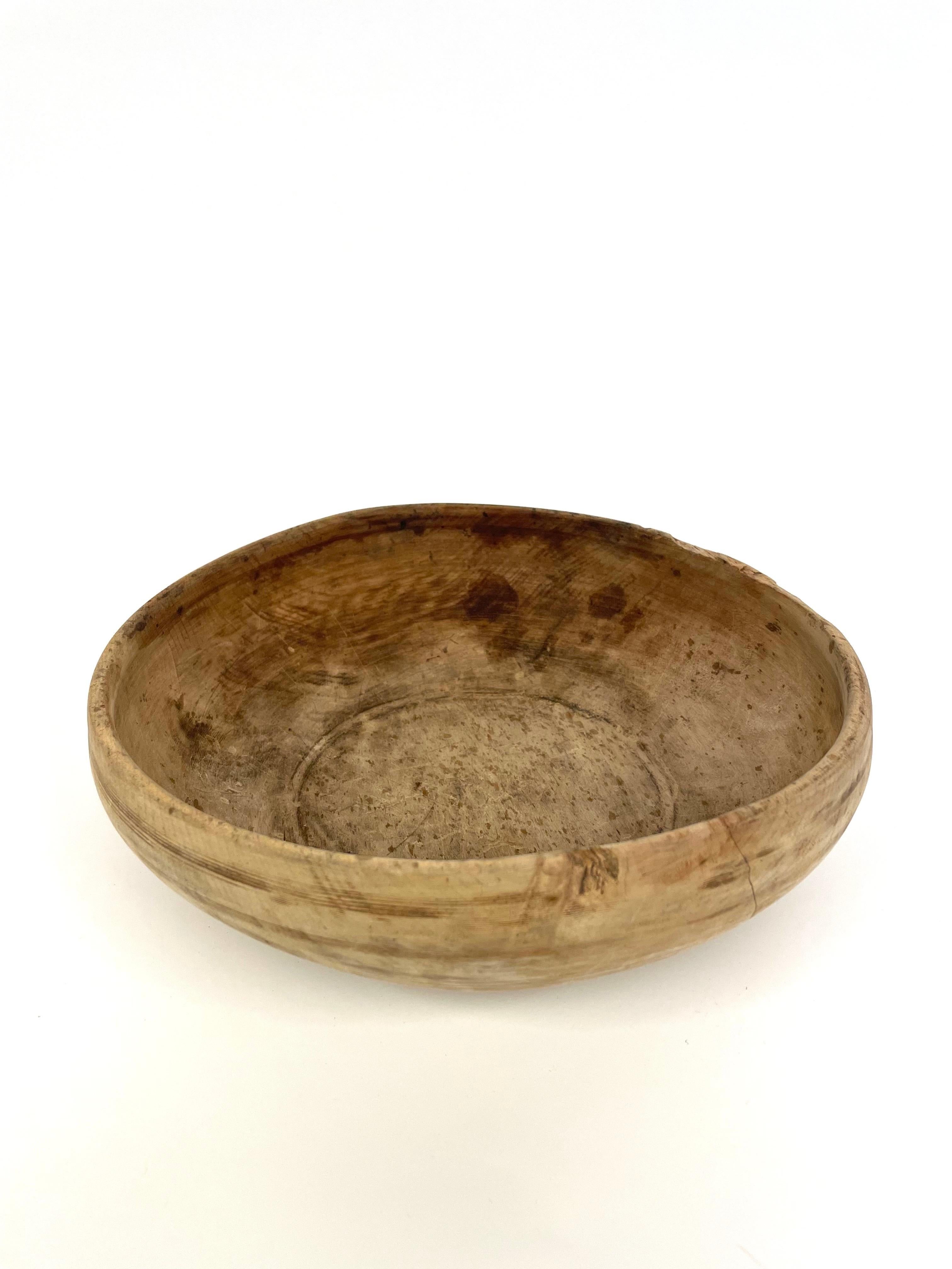This is a very beautiful Swedish hand-carfted 19th century wooden bowl in Wabi Sabi style. 
It comes made in pine with lovely patina reflecting its age and frequent use.
It has a few decorative longitudinal turned lines. 