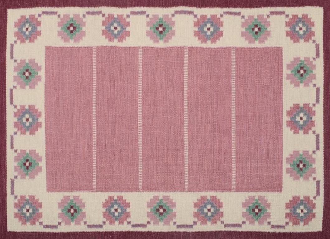 Swedish handwoven carpet in pure wool. Rölakan technique. 
Geometric pattern in blue, green, white, violet, and pink colors.
Mid-20th century.
In perfect condition.
Dimensions: 212 cm x 141 cm.