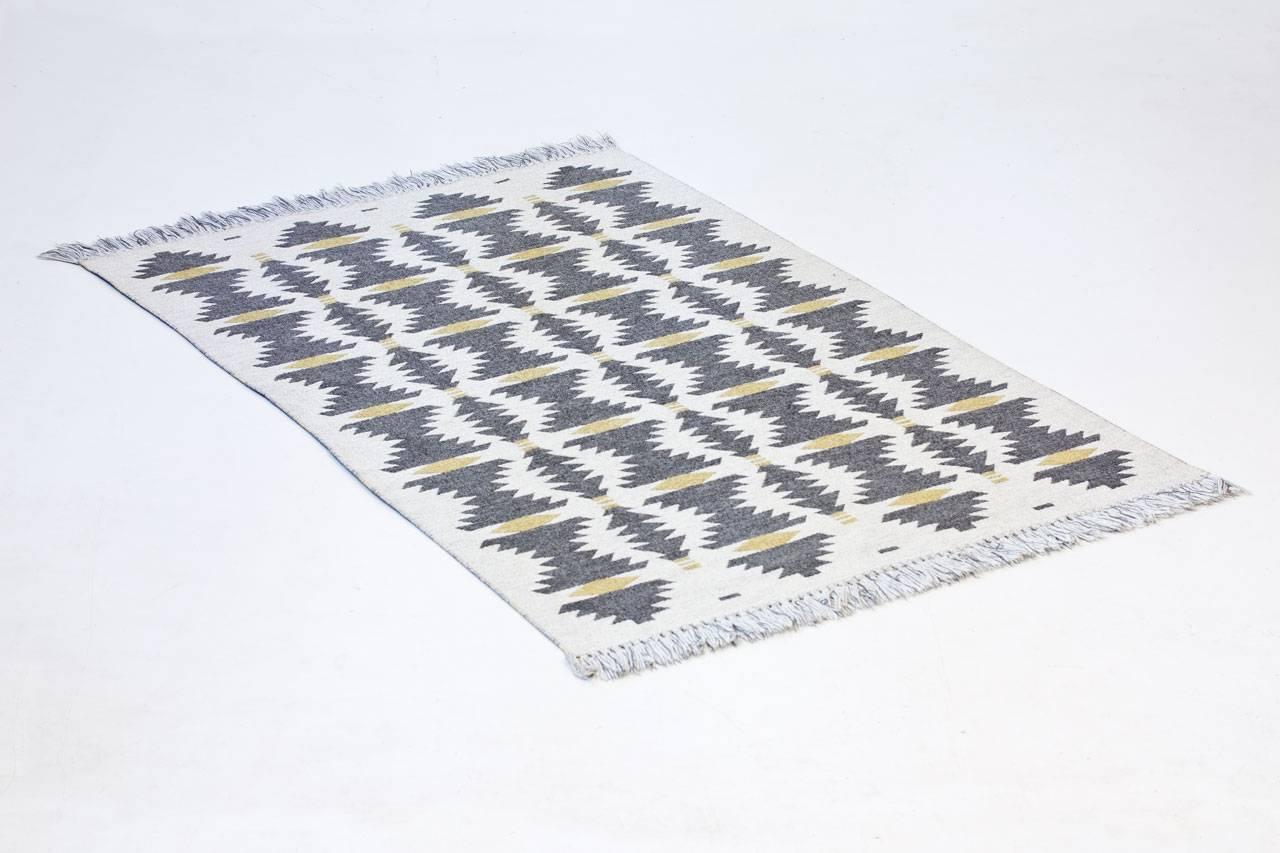Swedish handwoven wool carpet in “rölakan” flat-weave technique by unknown designer or maker. Made sometime during the 1950s with a double weave technique.
Repetitive geometric pattern in a mix of grey/ beige/ yellow. Rug in very good condition
