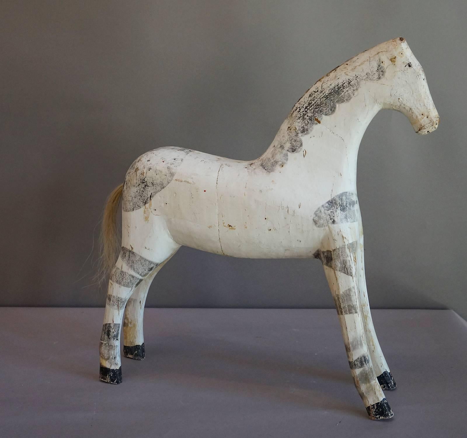 Primitive horse carving, Sweden, circa 1880, finished with grey paint made from fireplace ashes. Real horsehair tail. This horse, the only one of its kind we have seen, is truly a charmer.