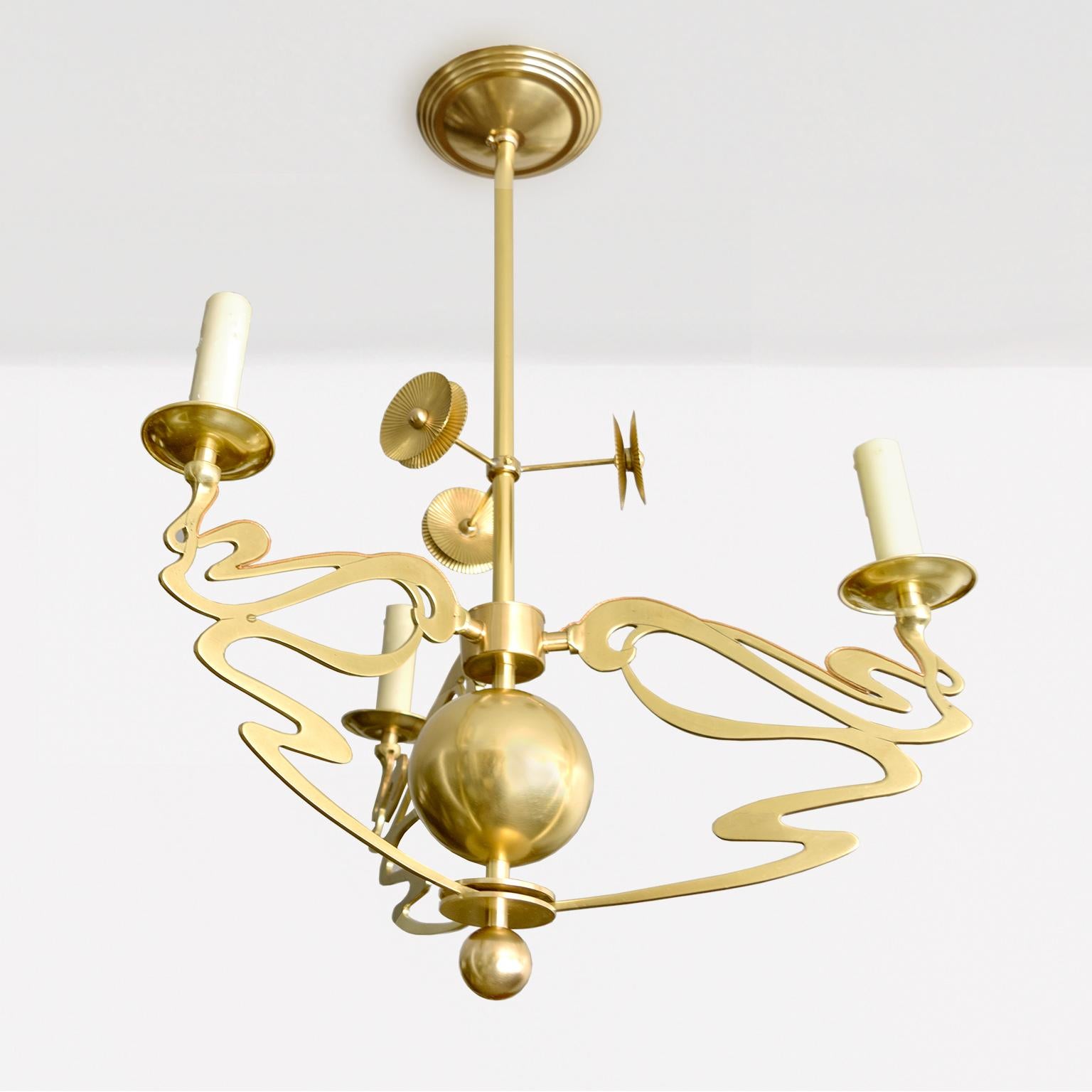 One of two Swedish Jugendstil 3-arm chandeliers in polished brass. Each chandelier has been newly restored, polished and lacquered. Newly electrified with candelabra sockets inside of wax covered sleeves. There are three floral inspired light