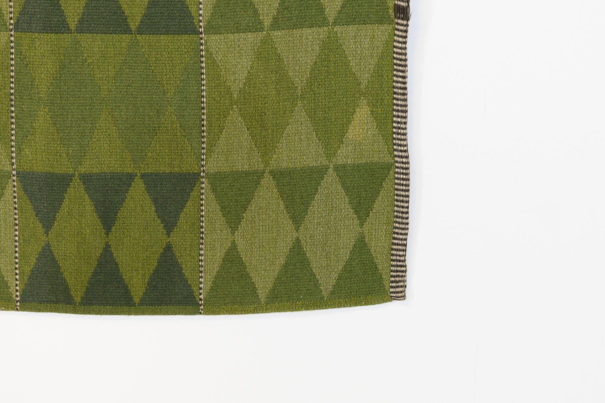 Magnifique kilim suédois à double tissage de qualité, dans les tons de vert, avec un motif en losange répétitif et des franges fouettées de couleur marron et crème. Suède vers 1960. Tous nos tapis sont soumis à un processus de nettoyage