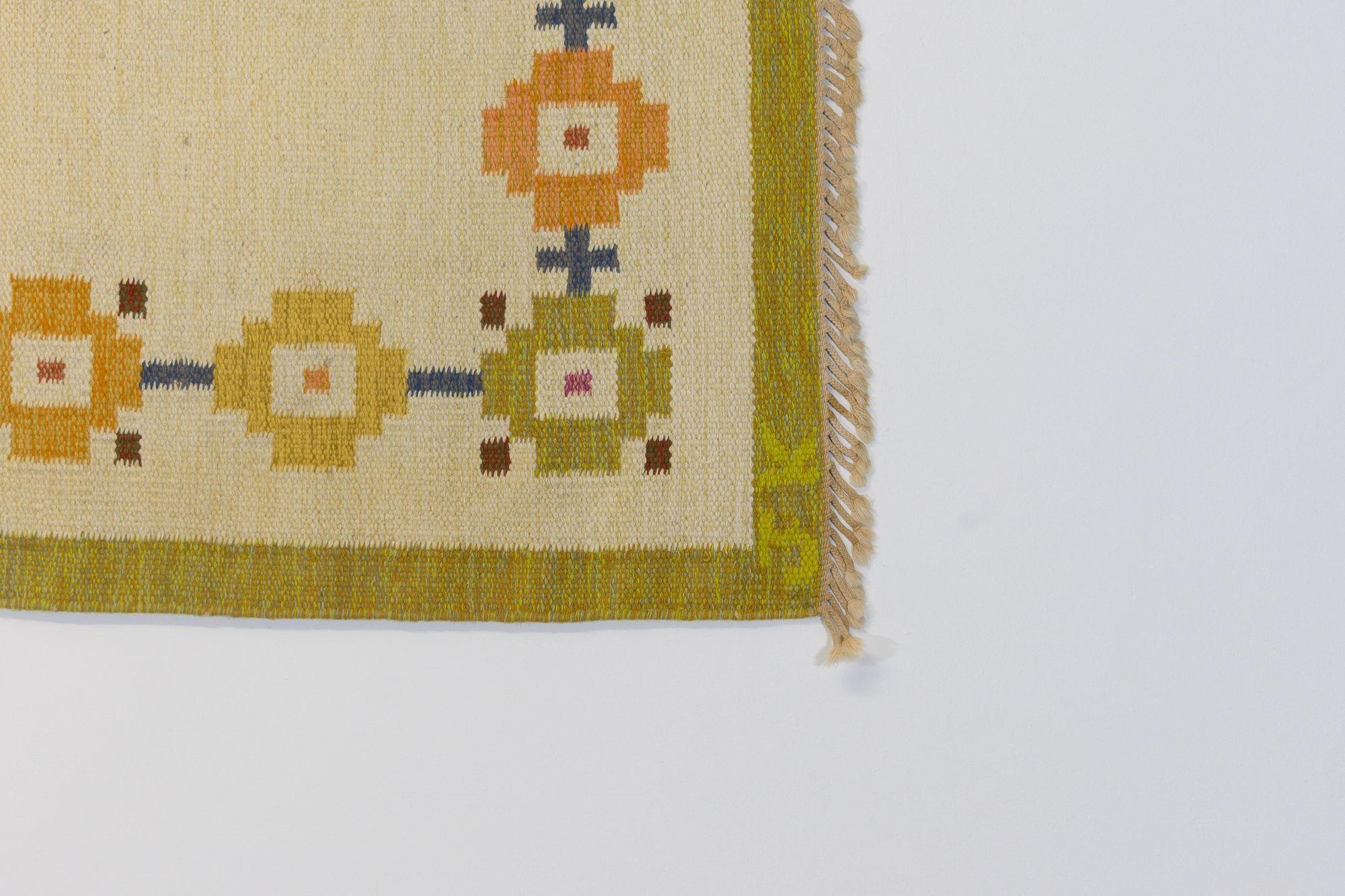 Kilim suédois du milieu du siècle dans des tons de jaune pâle et de vert. Signé J.K. vers 1960. Tous nos tapis sont soumis à un processus de nettoyage professionnel. Toutefois, en raison de leur âge et de leur vie antérieure, certains peuvent