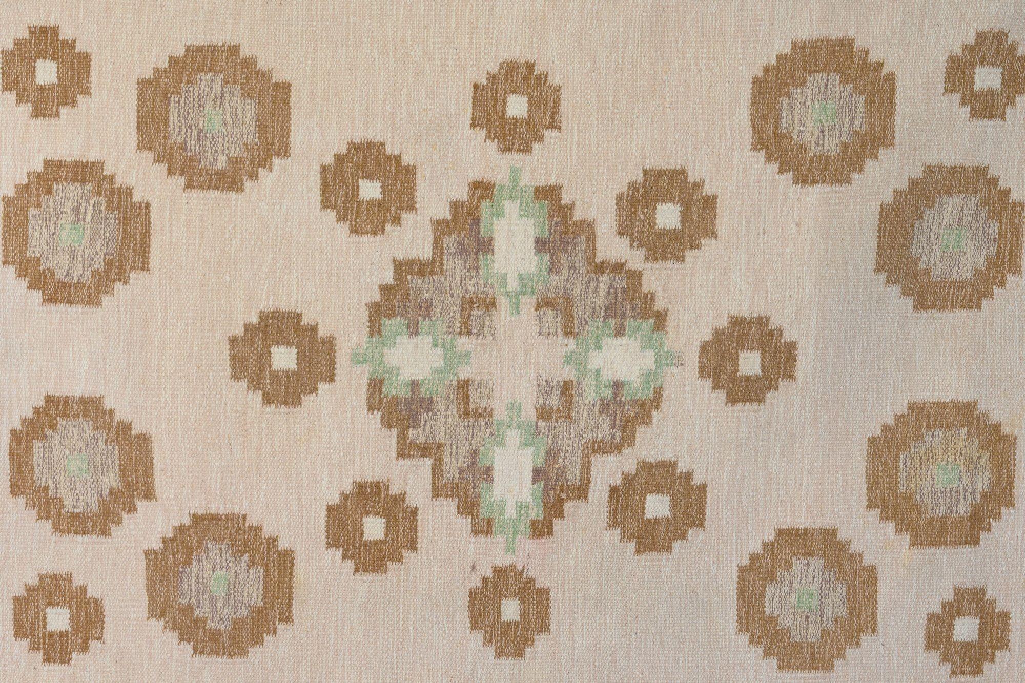 Kilim suédois du milieu du siècle dans des tons bruns et crèmes avec des touches de vert. Un modèle de bulle inhabituel signé E. Sweden circa 1960. Tous nos tapis sont soumis à un processus de nettoyage professionnel. Toutefois, en raison de leur