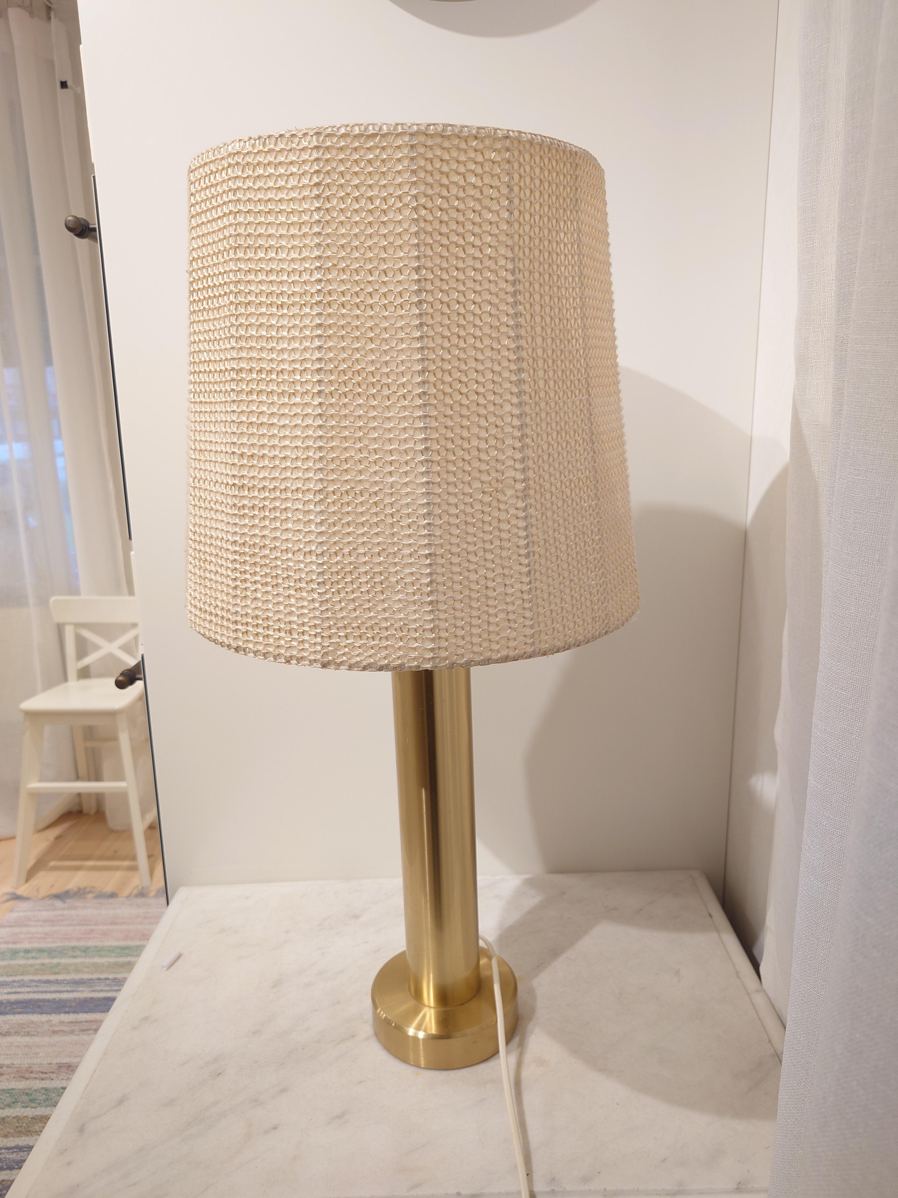 
Lámpara de sobremesa de latón sueco contemporáneo fabricada por la empresa experimental de vidrio Kosta hacia 1960. La lámpara está en buen estado original, con el desgaste propio de la edad y el uso. La lámpara viene con una gran pantalla de