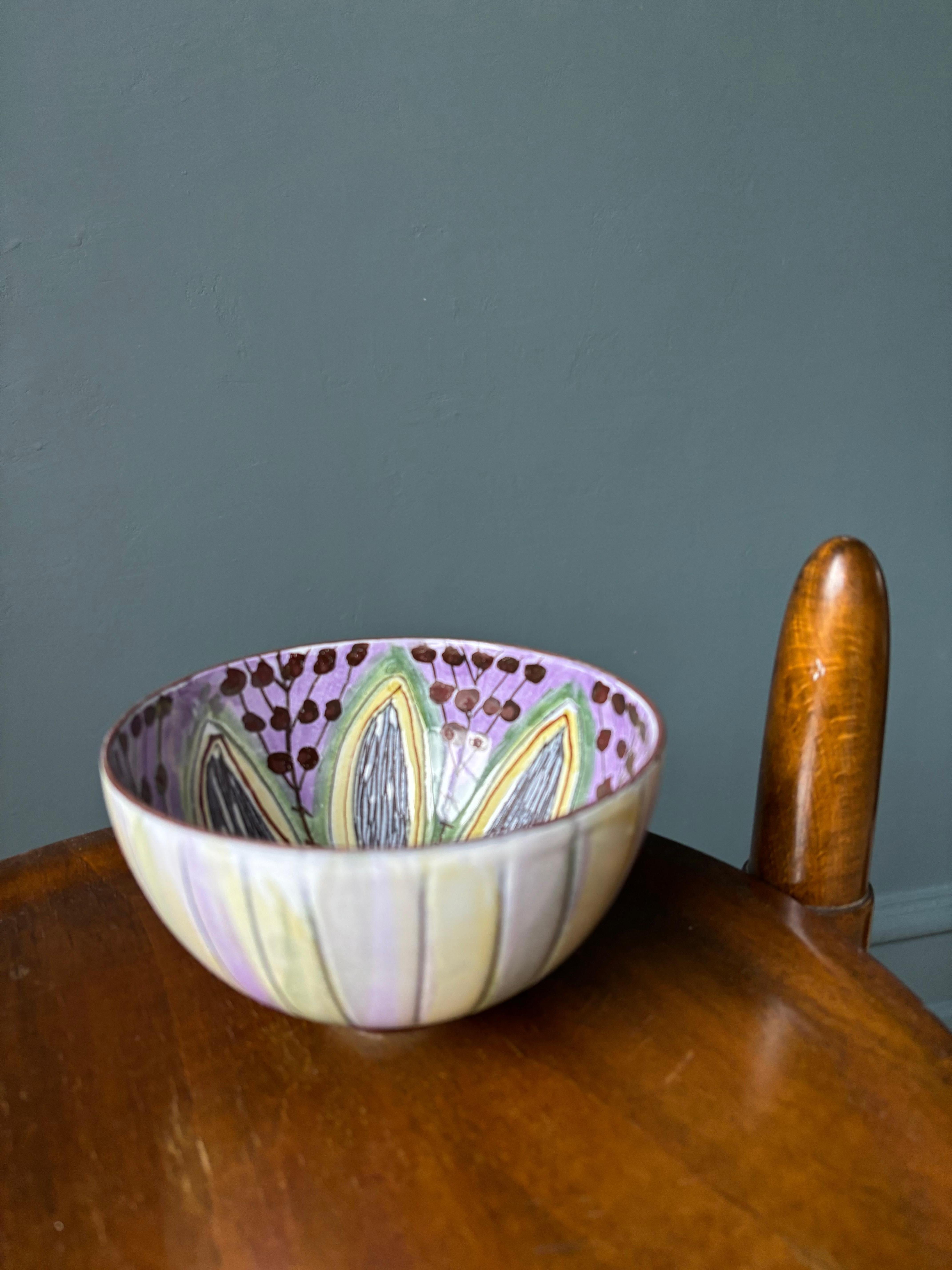 Handbemalte, mehrfarbige, dekorative Keramikschüssel der skandinavischen Moderne, hergestellt von Laholm in den 1960er Jahren. Zarte pastellfarbene Streifen auf der Außenseite und stilisierte Blütenblätter, Punkte und Linien auf der Innenseite in