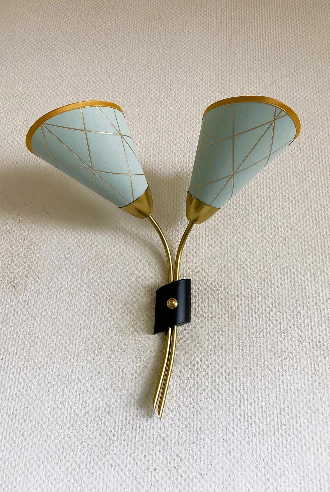 Aplique alto de dos luces, de latón y tela, diseñado y fabricado en Suecia en la década de 1940. Líneas limpias y diseño orgánico de la época moderna escandinava, dos brazos regulables con preciosas pantallas de tela plisada. l sistema de brazos