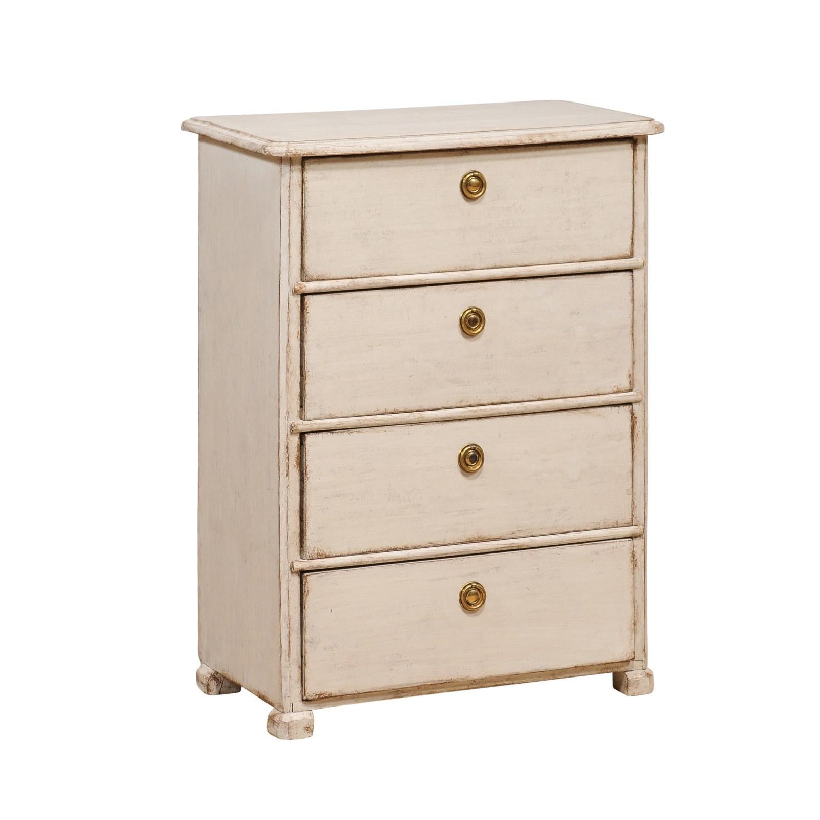 A Swedish painted wood bedside chest from the late 19th century with four drawers, brass hardware, petite block feet. Embrace the understated elegance of Nordic design with this late 19th-century Swedish bedside chest. This beautifully crafted piece