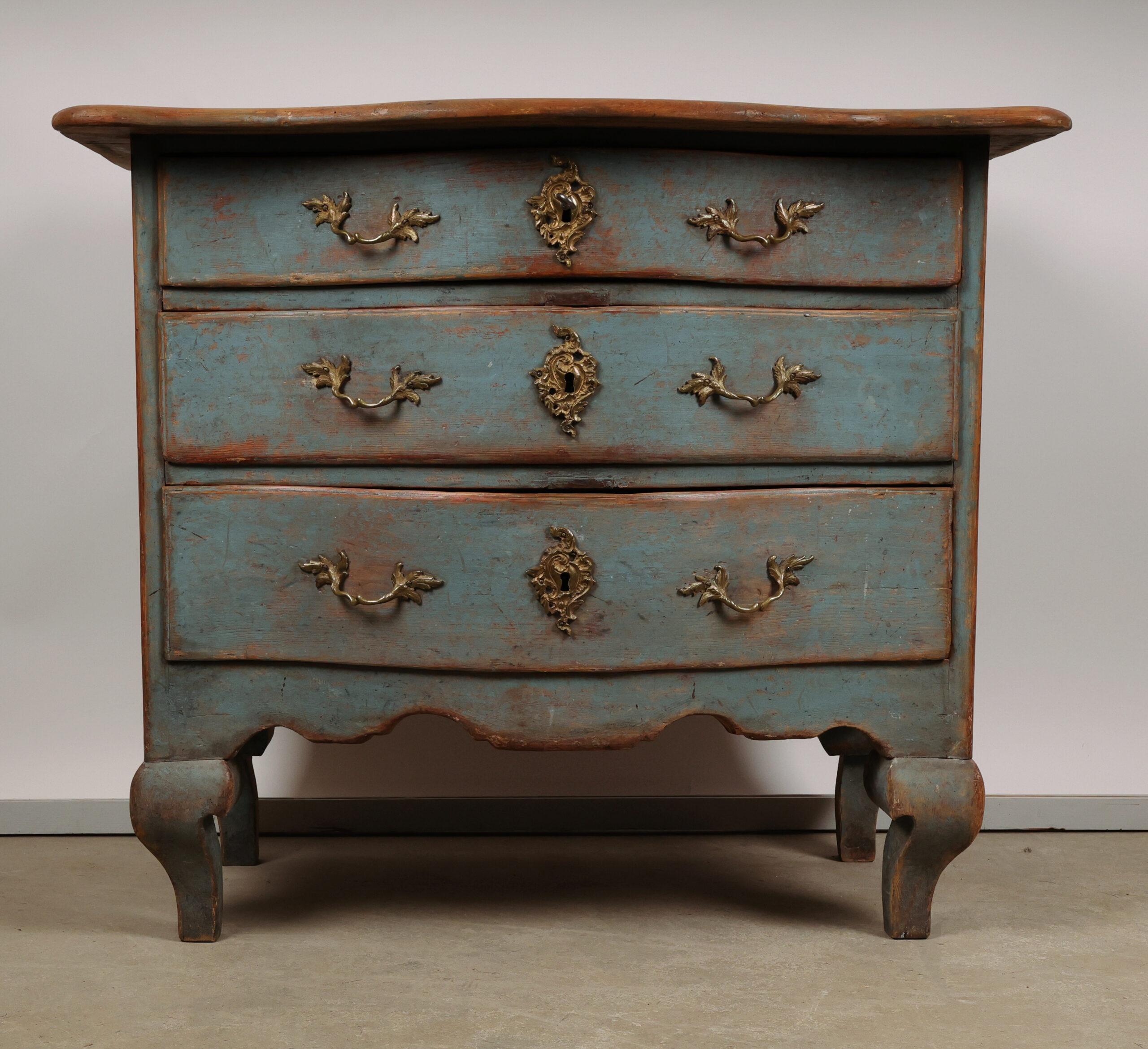 A Swedish Late Baroque chest of drawers made of pine in the mid-18th century. The bureau was likely produced in a provincial town. It retains its original legs, which are often replaced. The bureau has three drawers of varying sizes, with the top