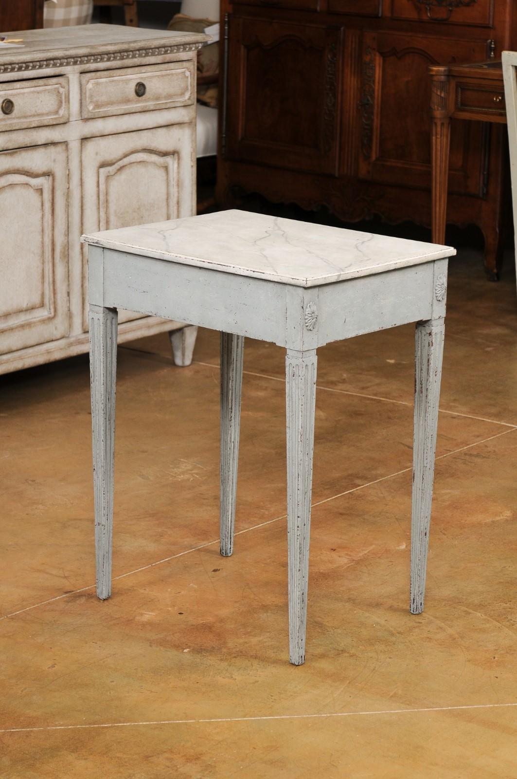 A Swedish Late Gustavian period painted wood console table from the early 19th century, with painted marbleized top, single drawer and carved rosettes. Created in Sweden during the first quarter of the 19th century, this painted console table